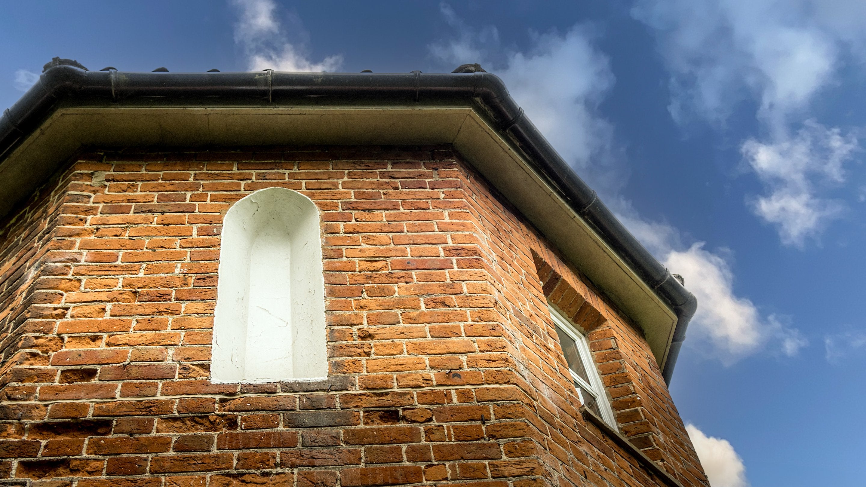 Looking up at the exterior of the first floor of Mustard Pot Cottage, which is an octagonal shape, Norfolk
