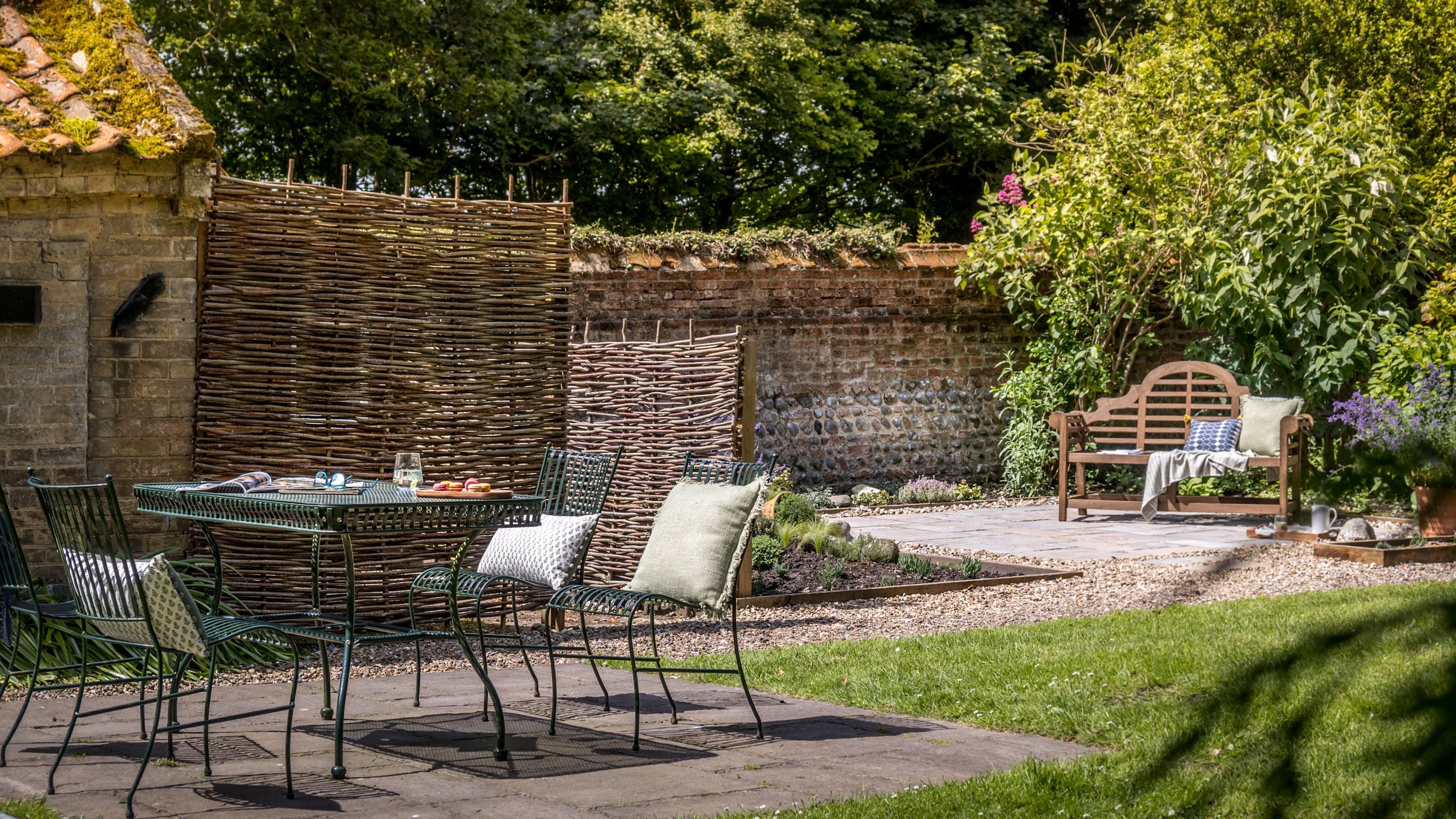 The garden at Sexton's Lodge has two patios. One with dining furniture and the other with a bench, Norfolk