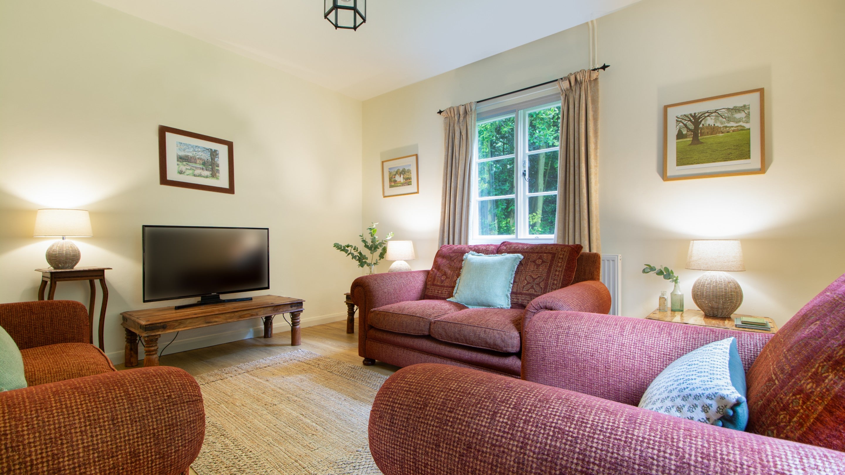 The sitting room with sofas and television, at Sexton's Lodge, Norfolk