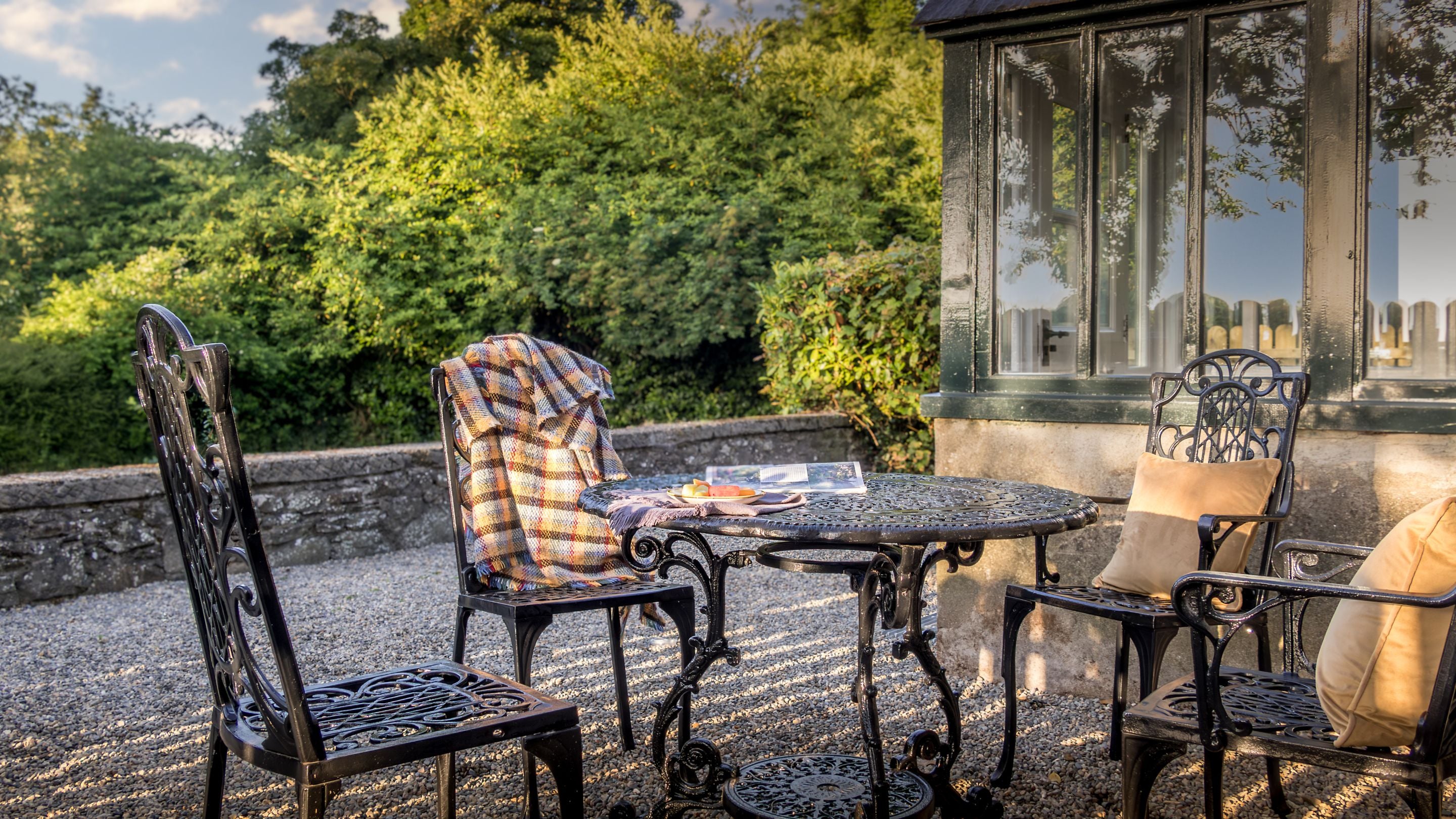 The outdoor dining furniture in the gravelled area of the garden at Castle Ward Gamekeeper's Lodge, County Down