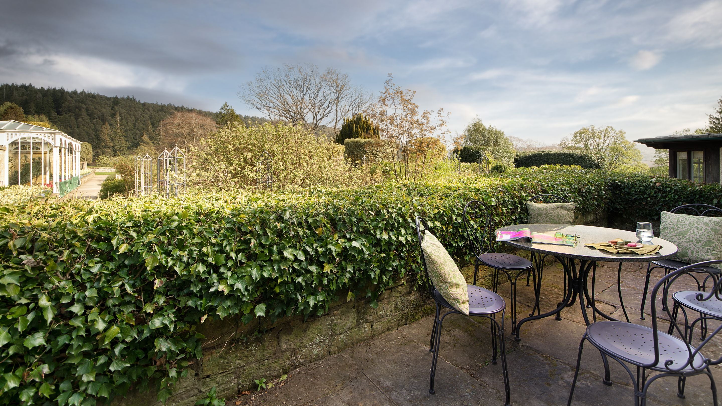 The private terrace at Cragside Garden Cottage, accessed by glass doors from the kitchen and dining room, Northumberland