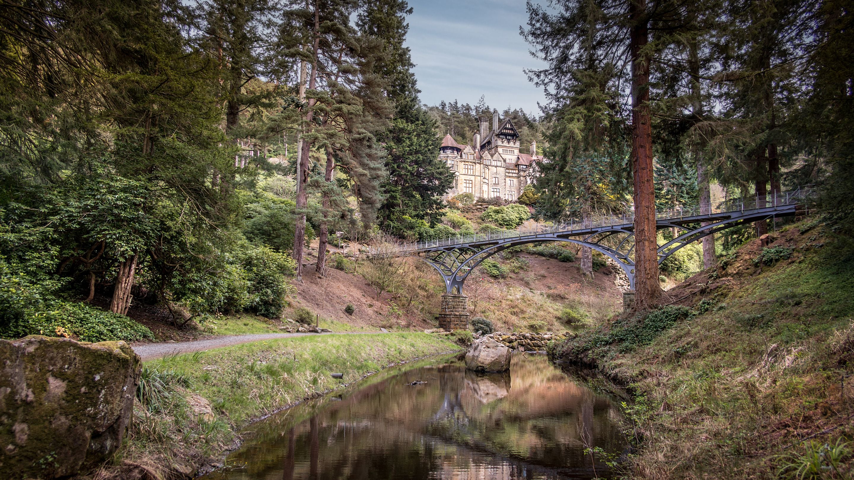 Looking up at the house and iron bridge at Cragside from the gorge, Northumberland