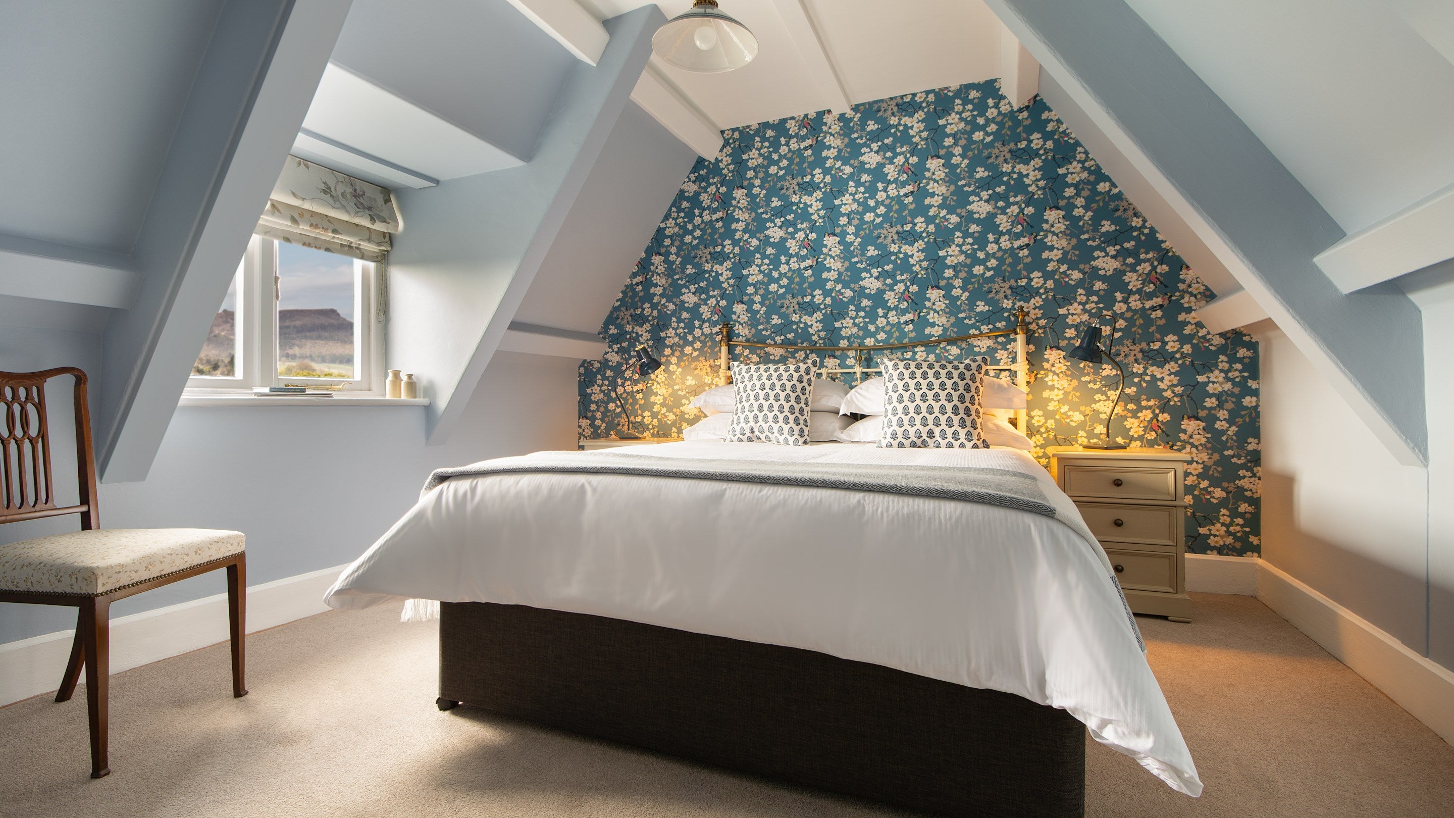 The double bedroom in the eaves of the first floor of Cragside Park Cottage, with sloped ceilings, Northumberland