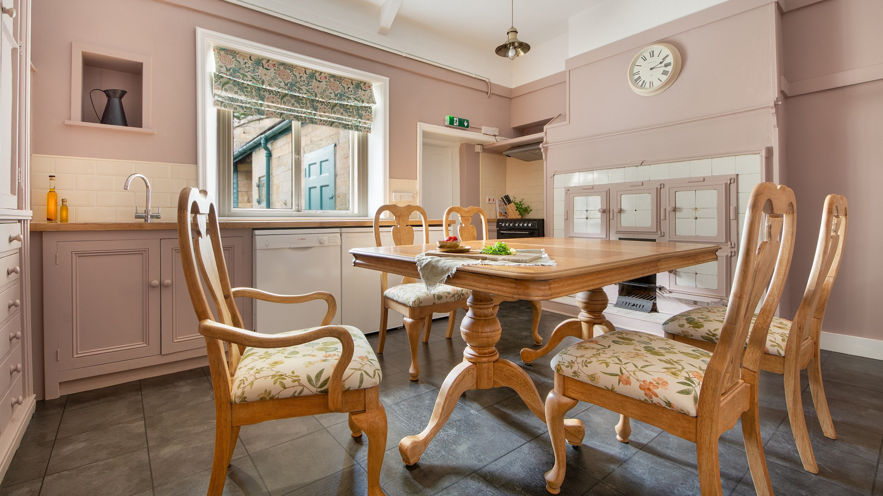 The kitchen at Cragside Park Cottage, with table for six and old bread ovens on the right, Northumberland