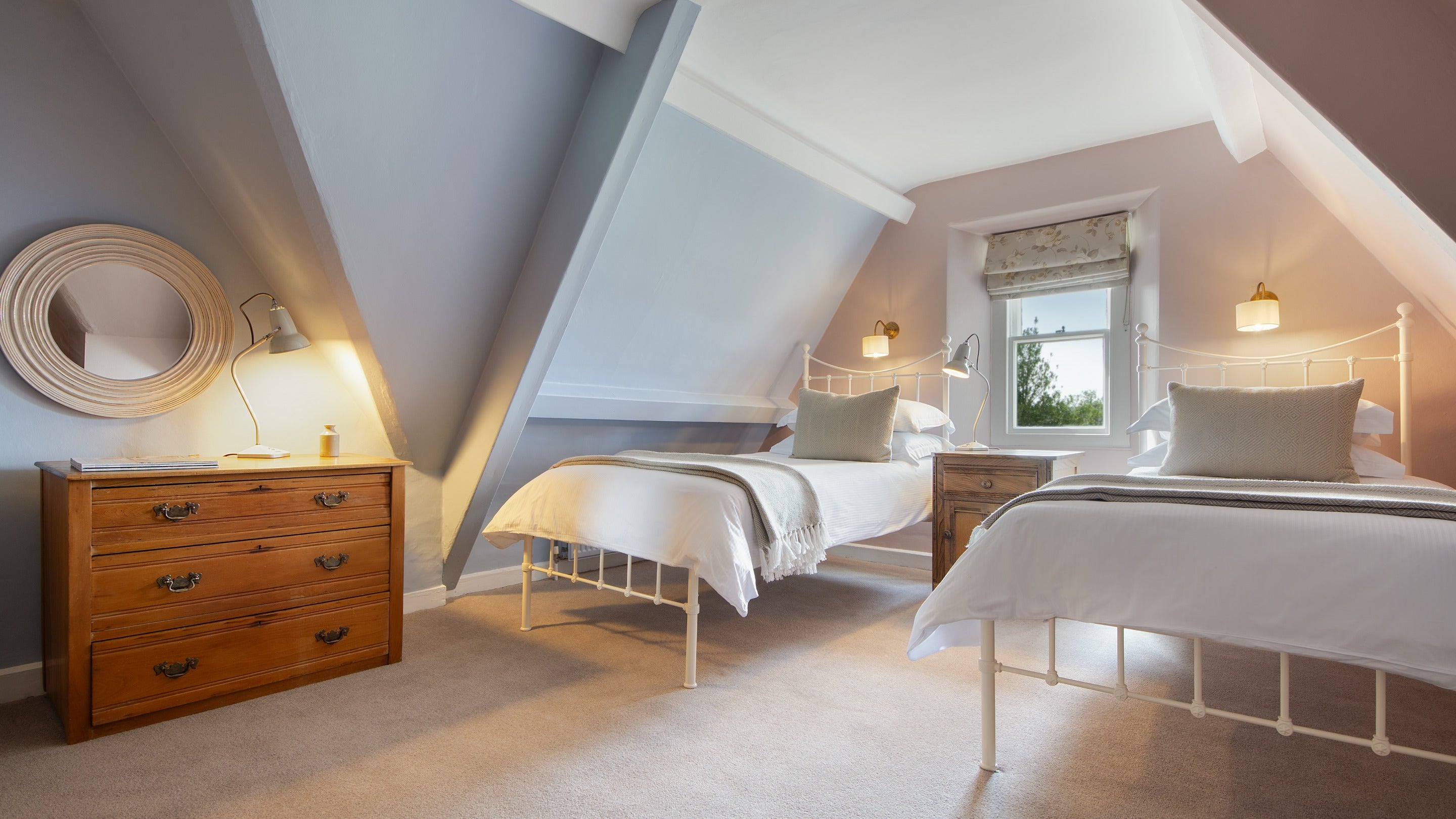 The twin bedroom in the eaves of the first floor of Cragside Park Cottage, with sloped ceilings, Northumberland