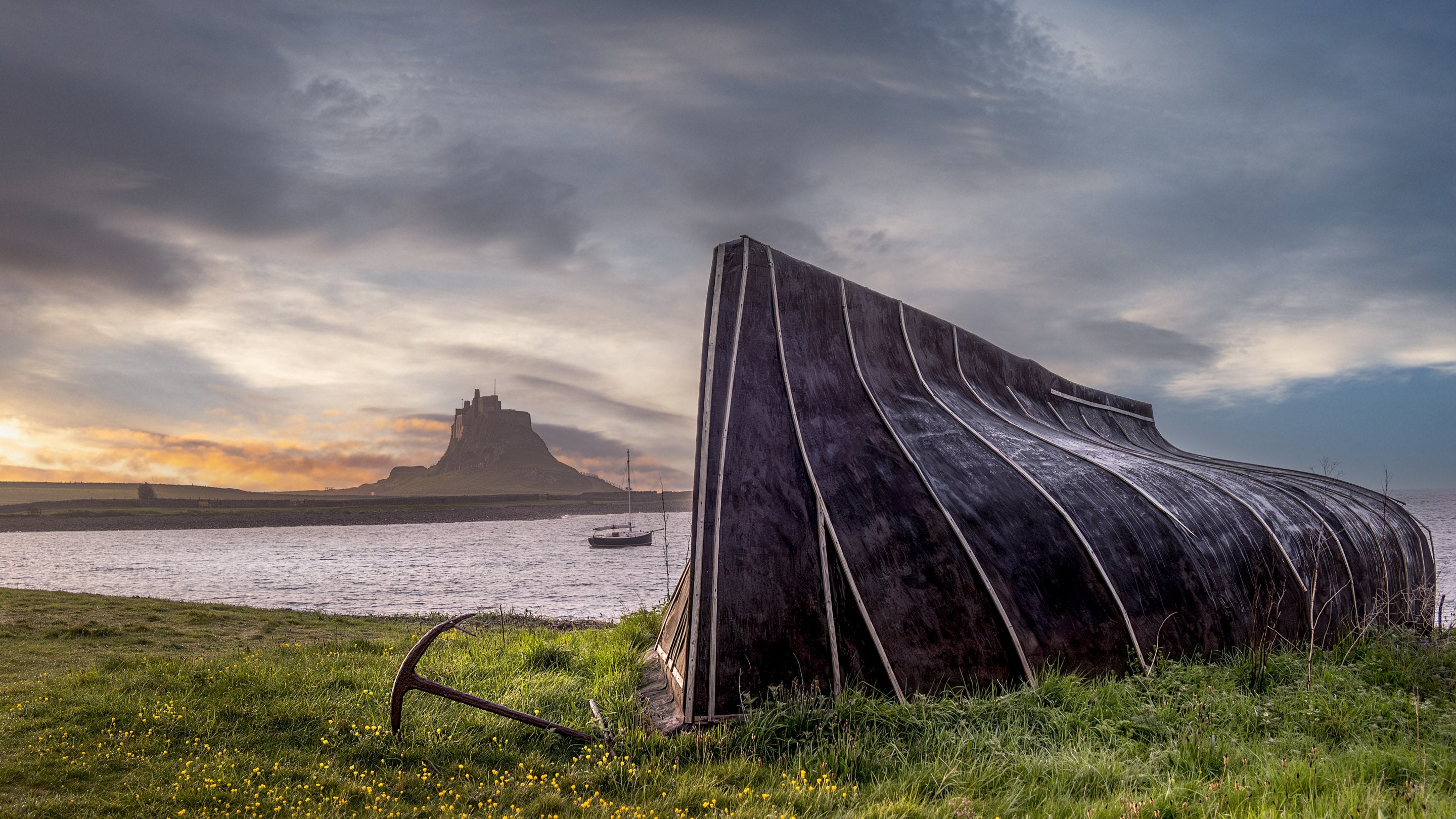 A boat shed on Holy Island with Lindisfarne Castle in the background, near Glen House, Northumberland