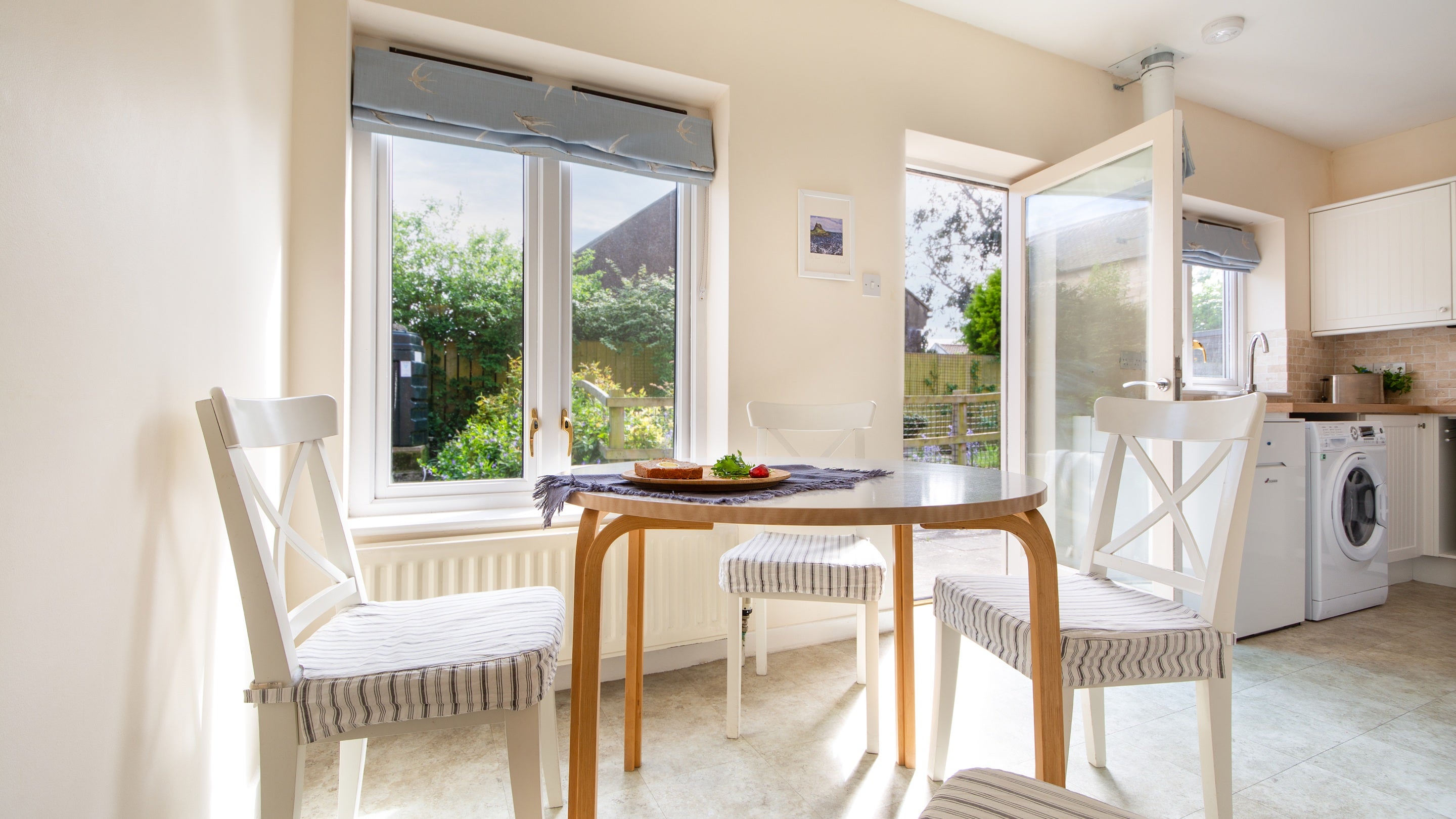 The open-plan kitchen and dining room with table and chairs for four, washing machine and tumble dryer at Glen House, Northumberland