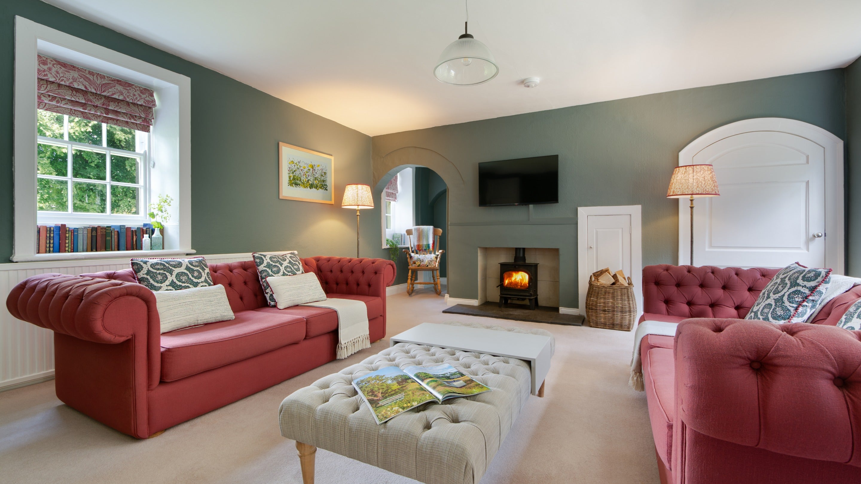 The sitting room, with sofas, television and woodburner at Laundry Cottage, Northumberland