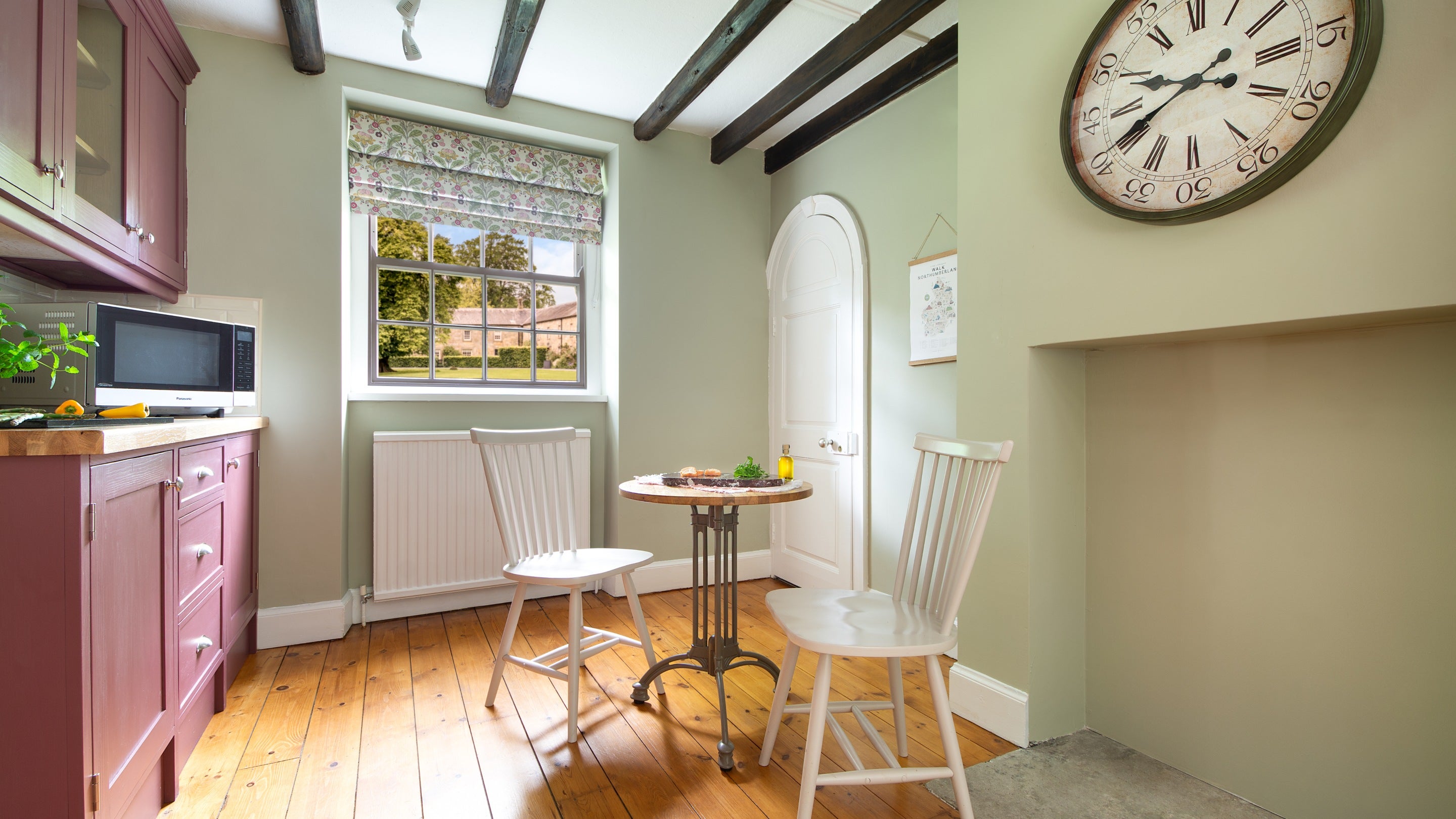 The kitchen with a microwave and small breakfast table for two at Laundry Cottage, Northumberland