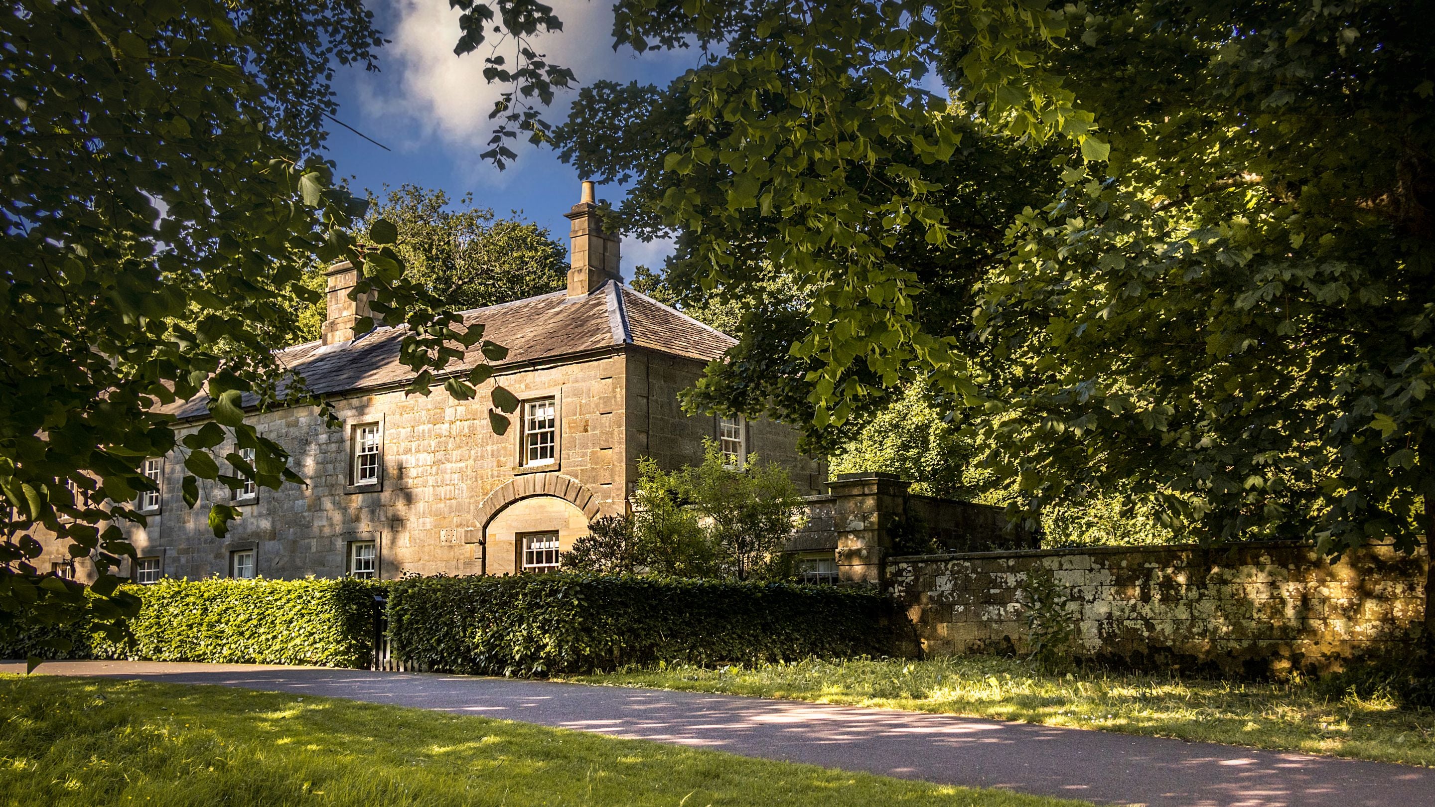 The front exterior of Laundry Cottage and the path that leads past it towards the house at Wallington, Northumberland