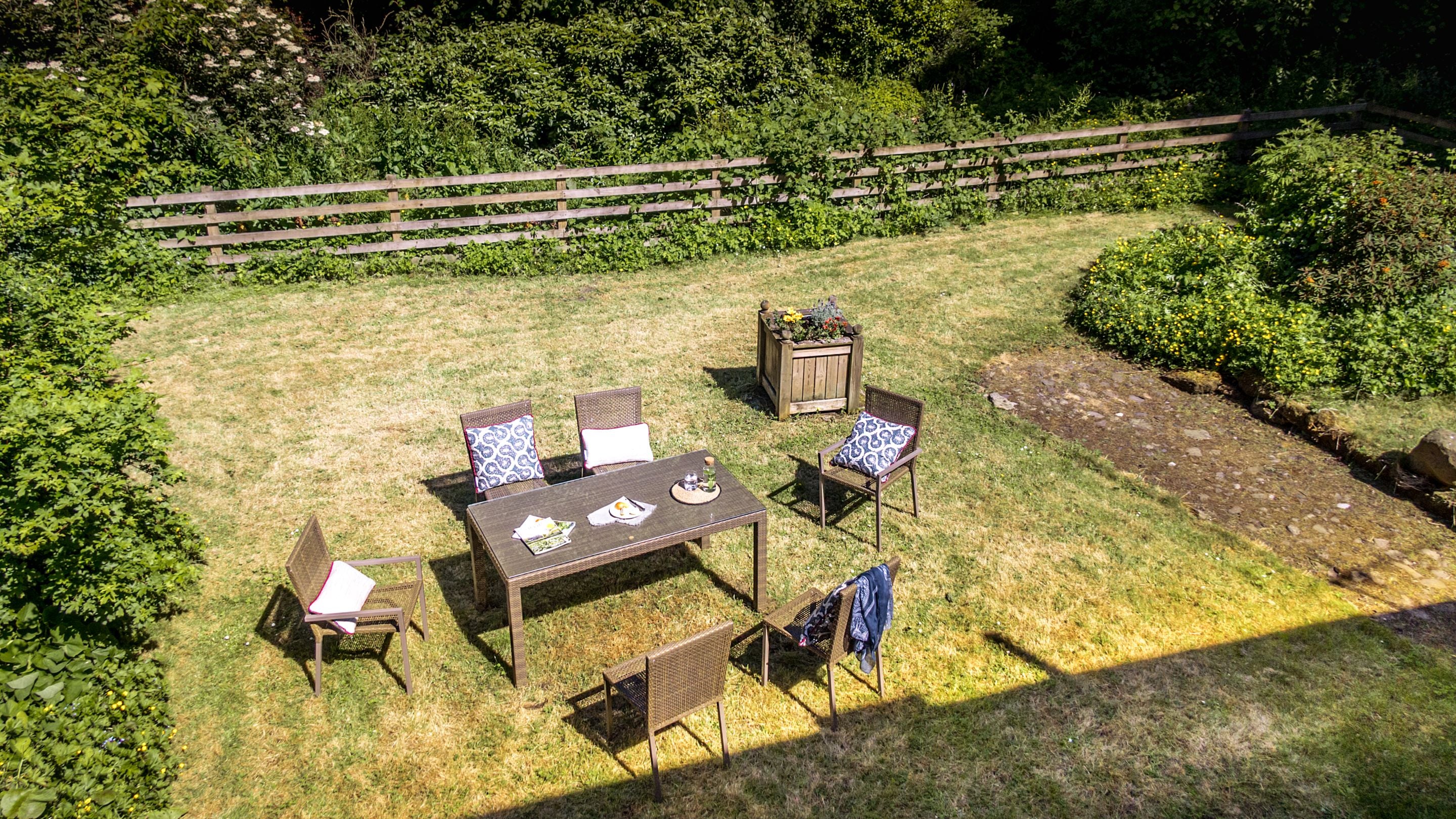 The lawned garden with dining furniture for six at Laundry Cottage, Northumberland