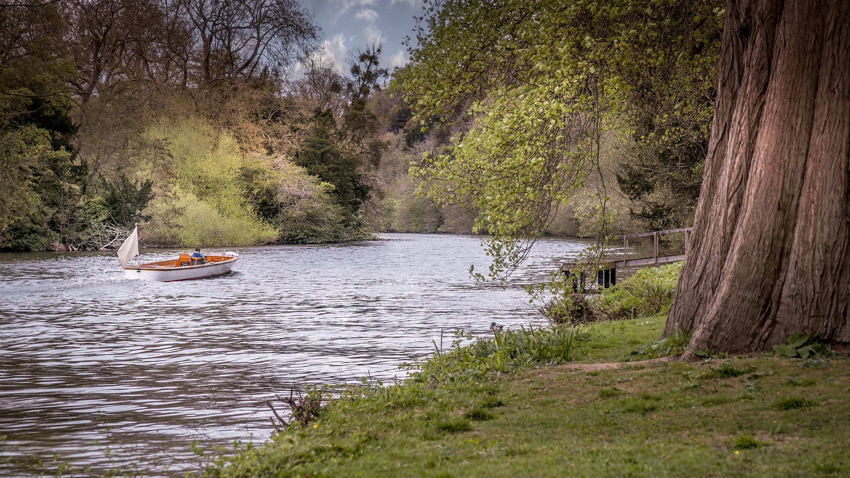 A boat travelling on the River Thames at Cliveden, Berkshire