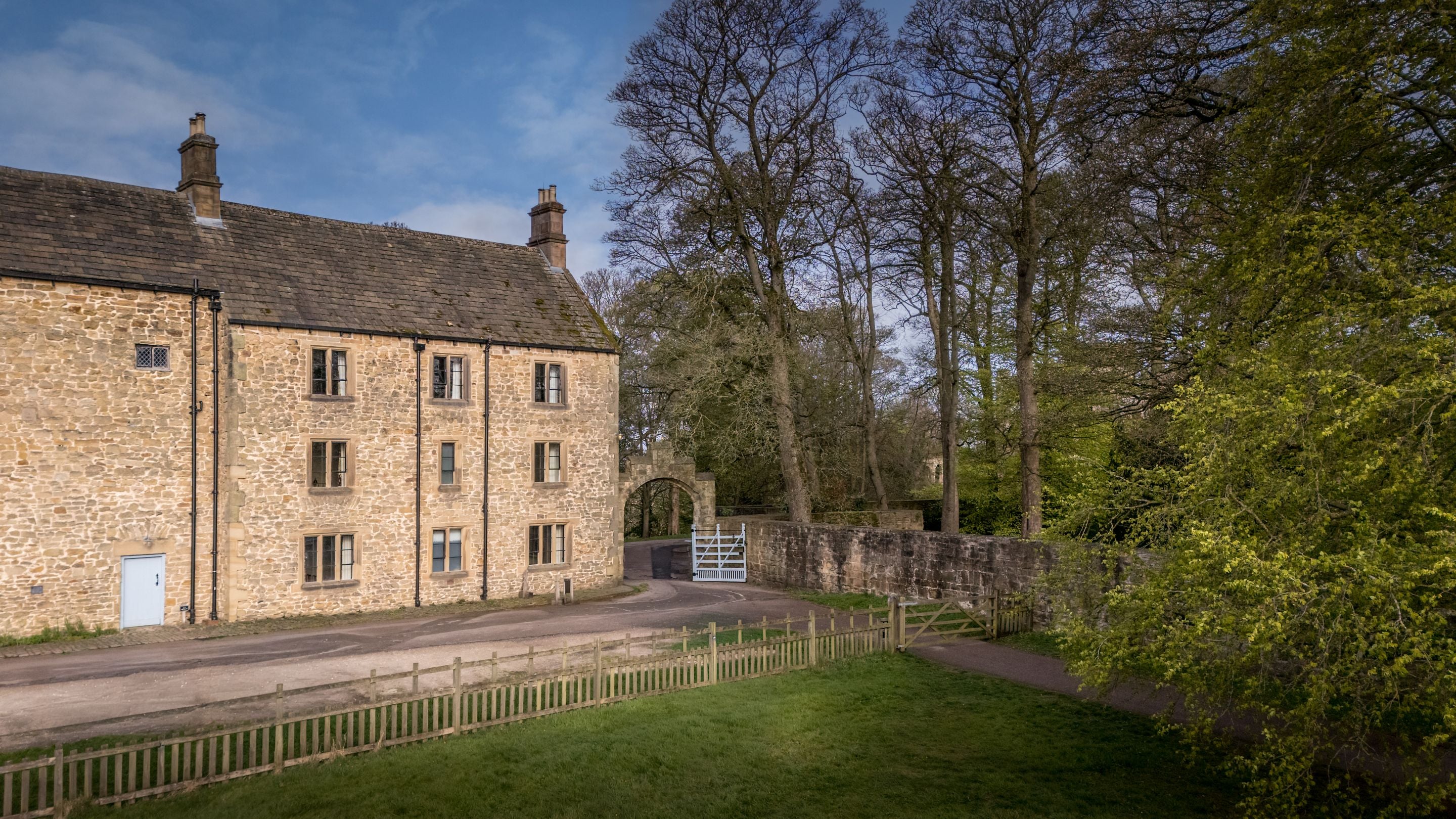 An aerial view of 6 High Hazels and its parking space, next to the grass field of the Stable Yard at Hardwick, Derbyshire