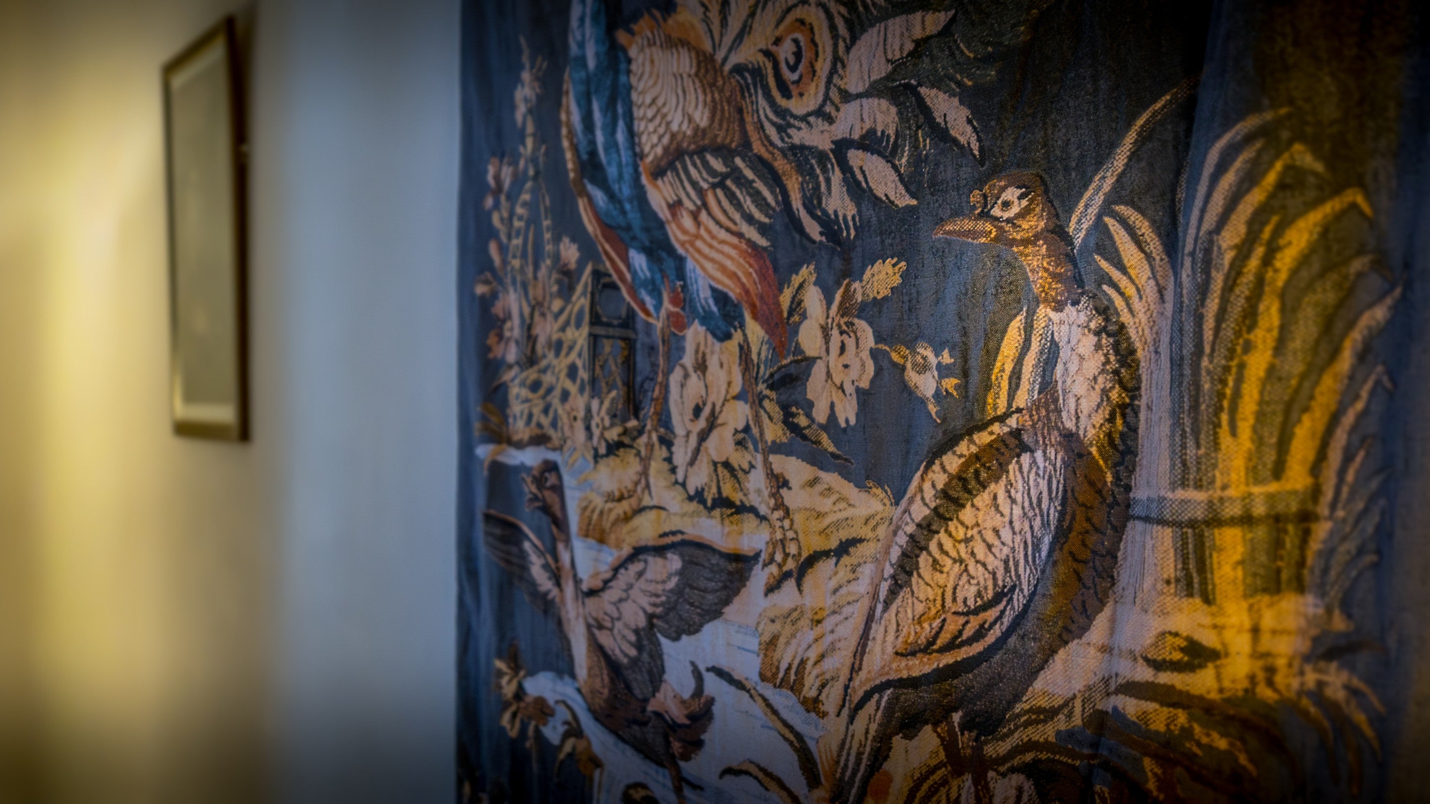 A close-up view of the tapestry in the sitting room at 6 High Hazels, showing birds and flowers on a blue background, Derbyshire