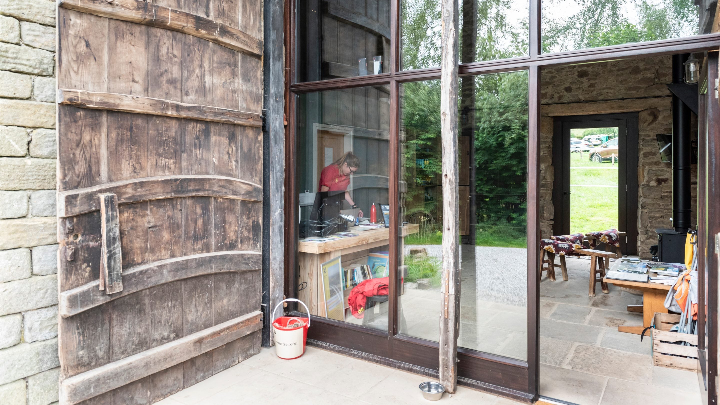 Reception, with woodburner, benches and information about the local area, at Upper Booth Farm Campsite, Derbyshire