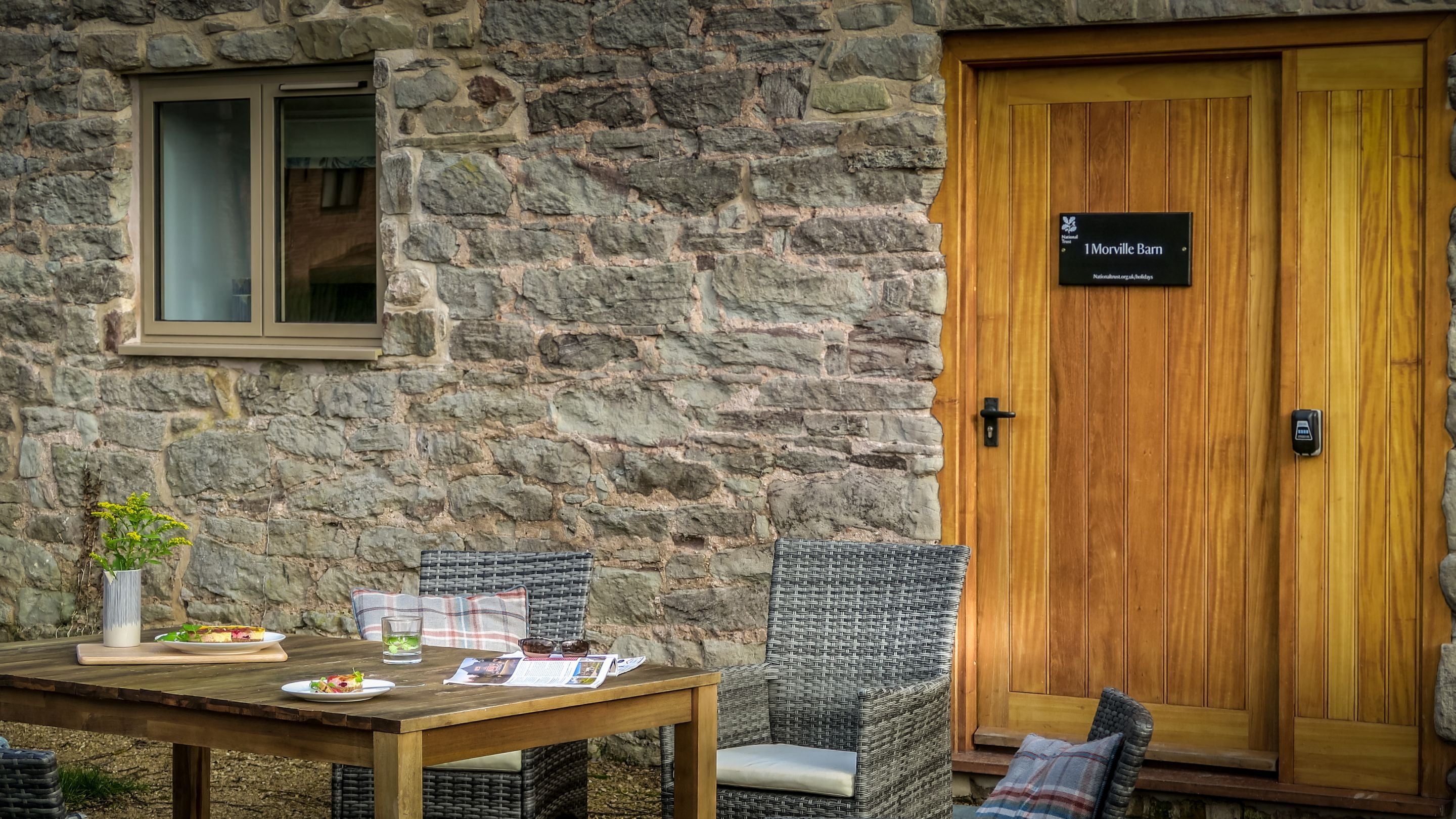 The front door and outdoor seating at 1 Morville Barn, Shropshire