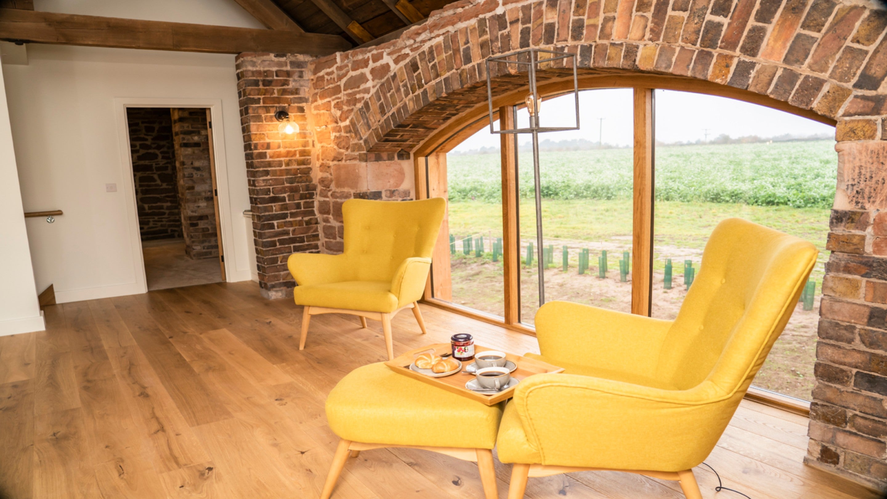 The first-floor mezzanine, with two armchairs, at Sandybury Barn, Shropshire