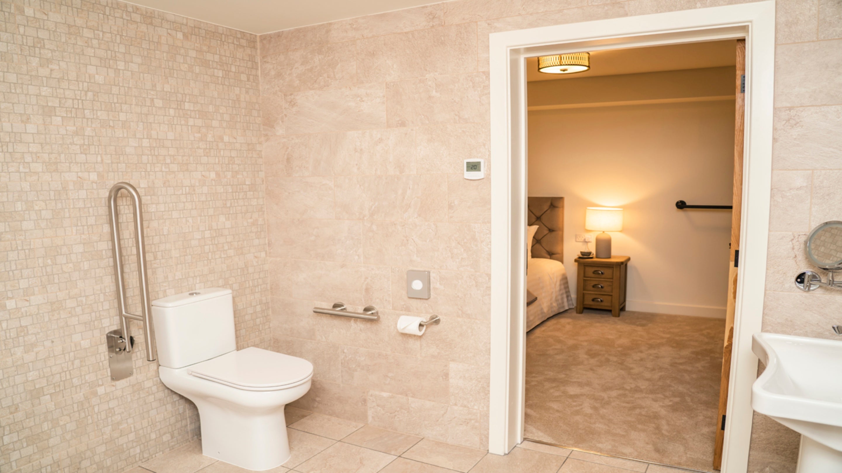 The entrance to the accessible wet room from the ground-floor double bedroom at Sandybury Barn, showing the toilet with grab rail, Shropshire