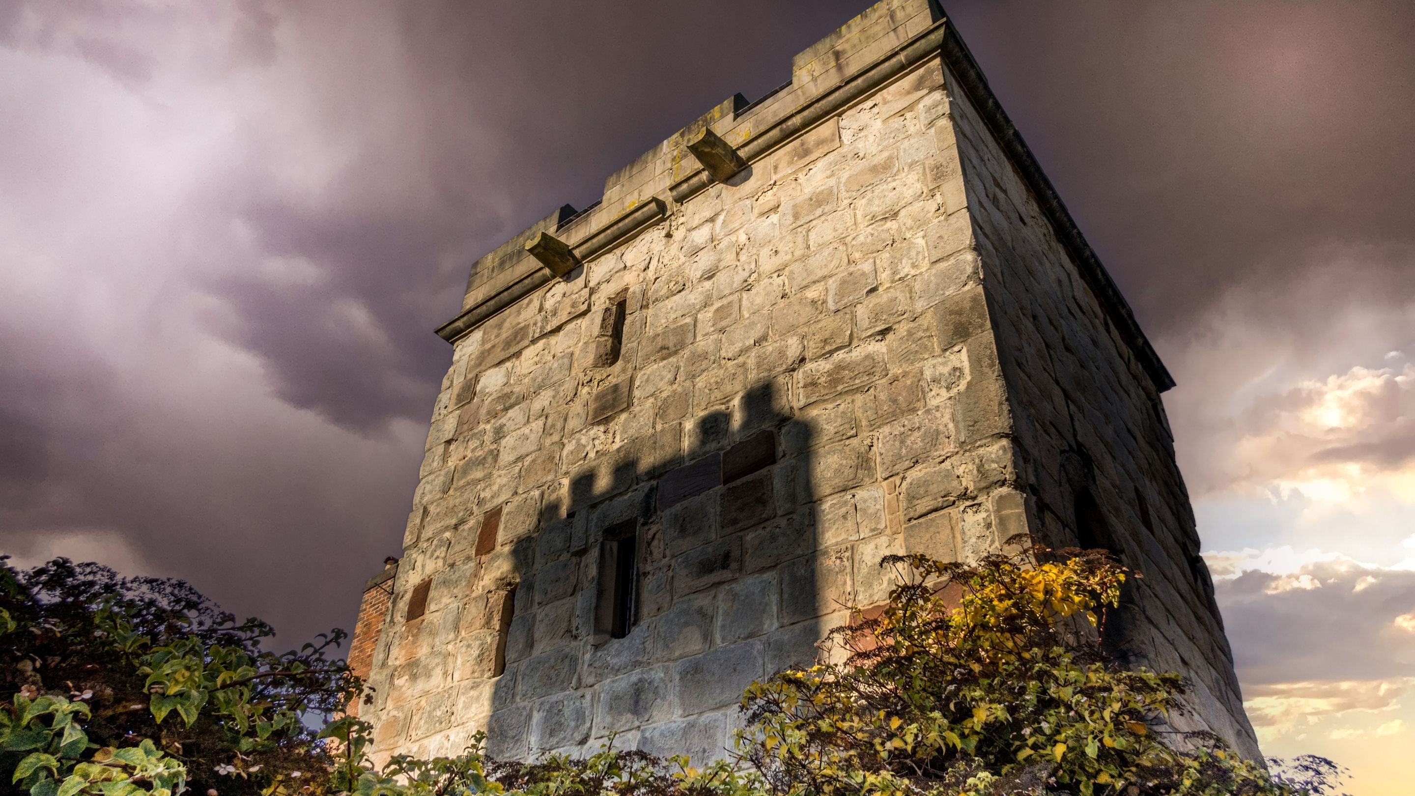 The exterior of Town Walls Tower below a stormy sky, Shropshire
