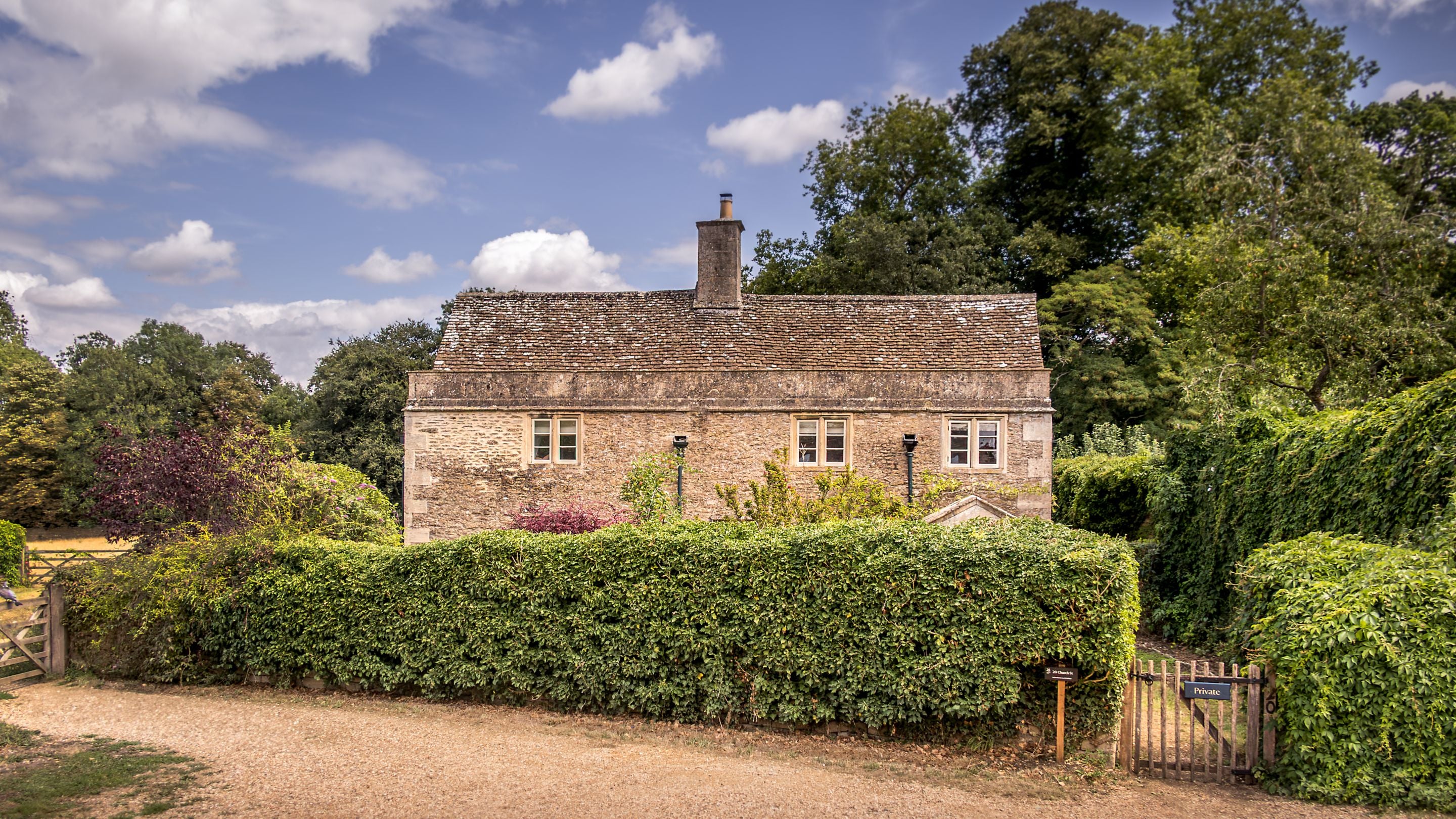 The front of 20 Church Street, viewed from the street, with the garden hedge covering most of the ground floor from view, Wiltshire