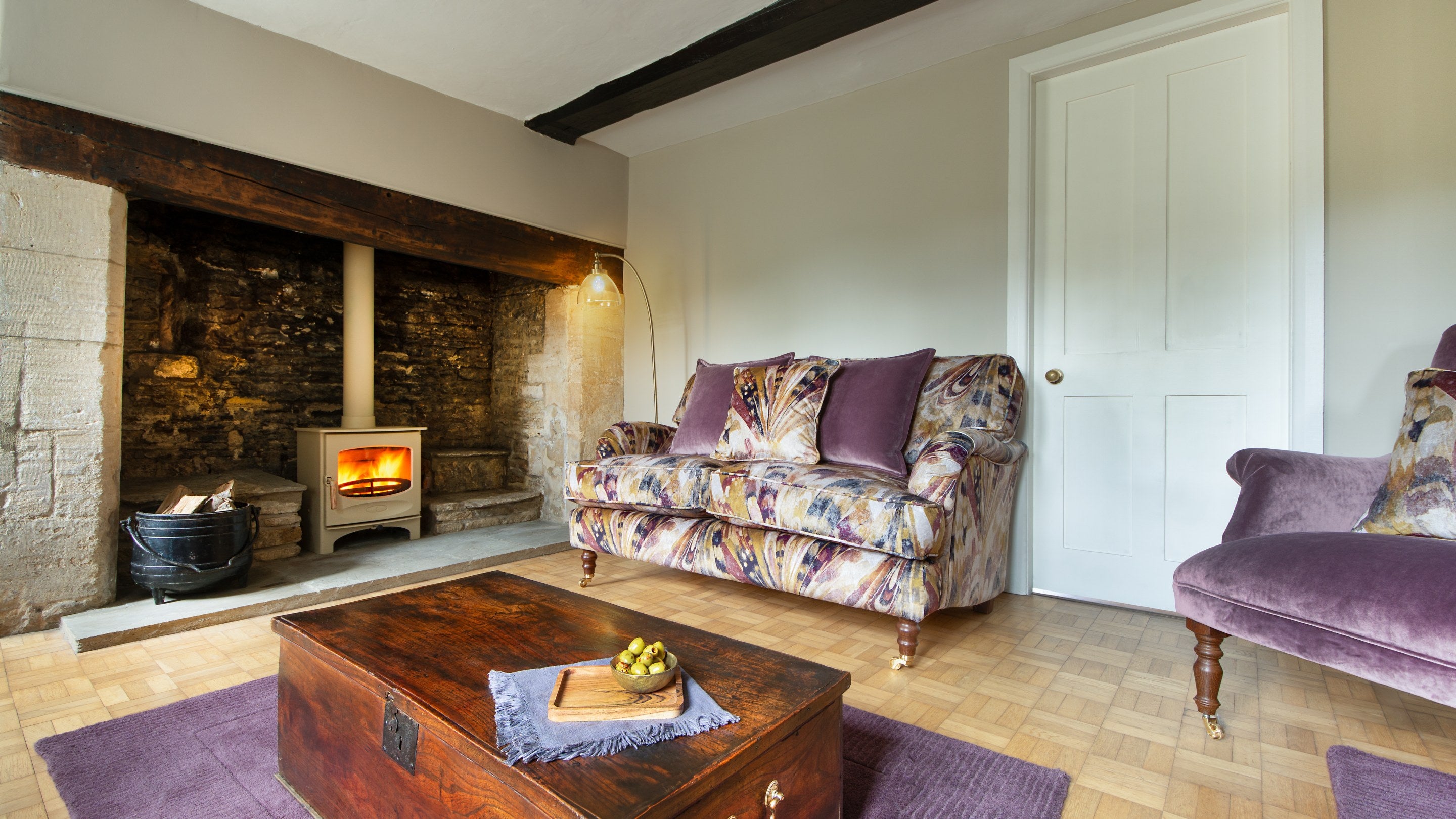 The sitting room at 20 Church Street with woodburner in the original inglenook, Wiltshire