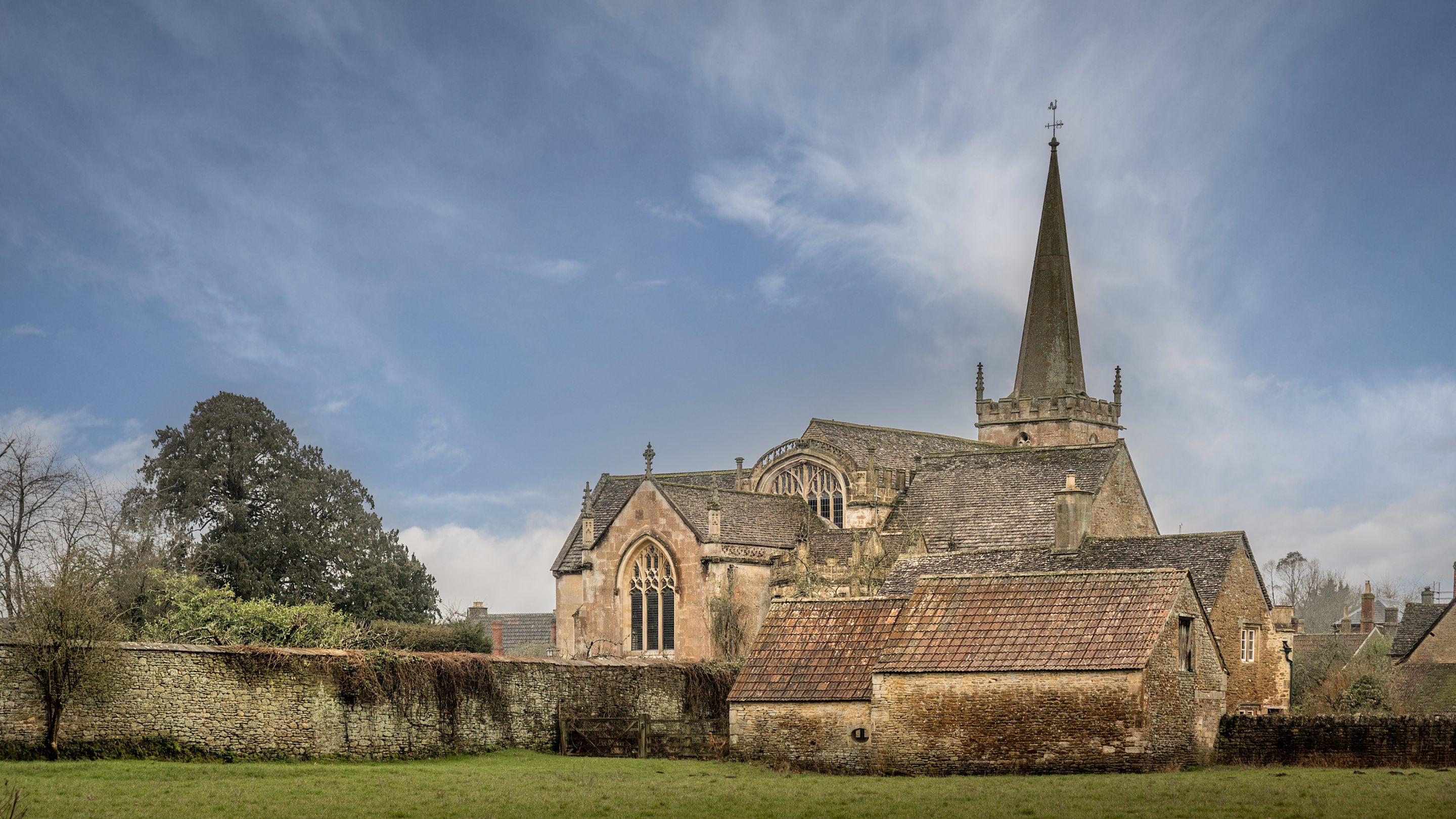 The back of 20 Church Street and it's outbuildings, overlooked by the village church, Wiltshire