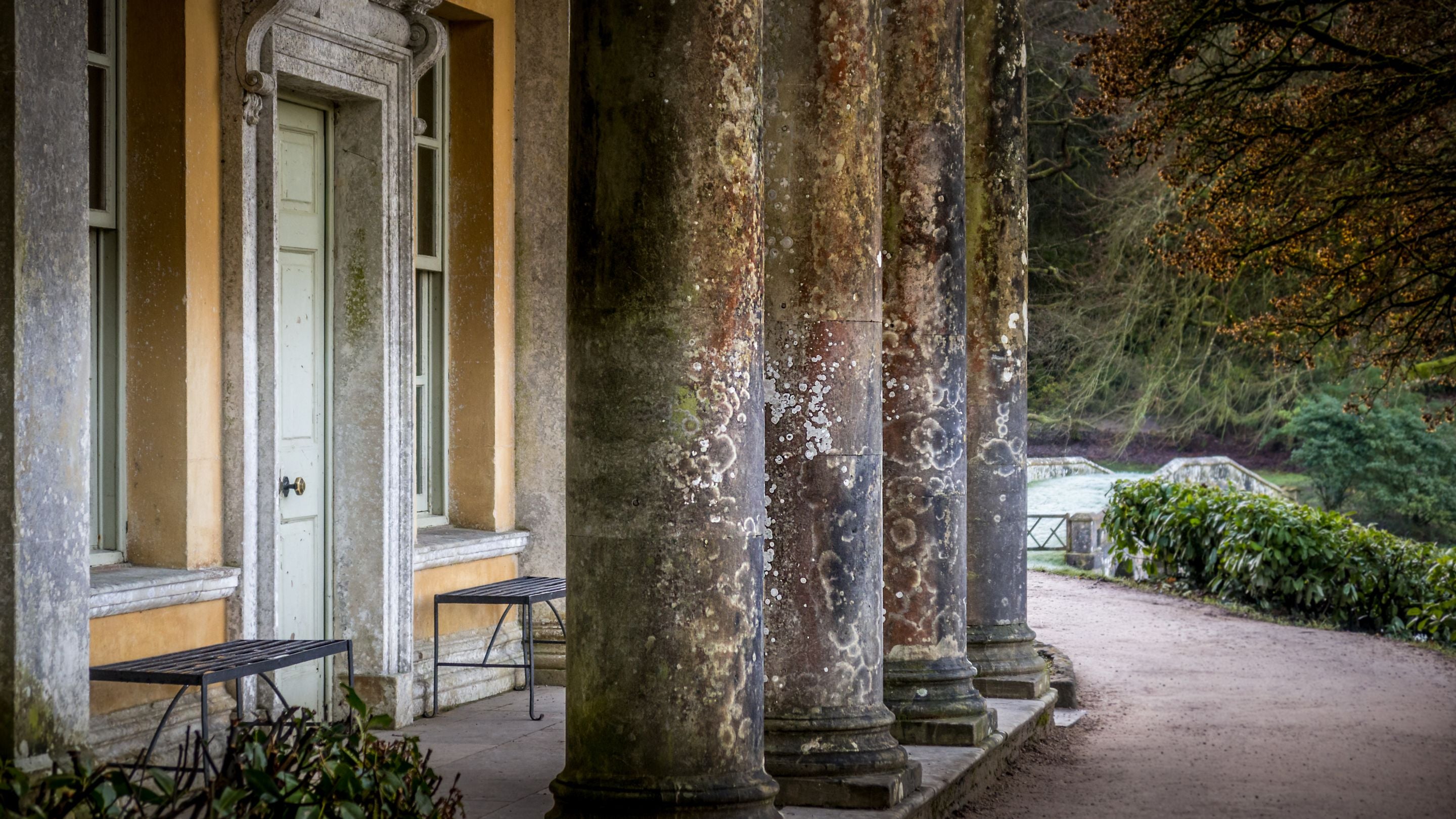 A path passing the stone columns of one of the buildings in Stourhead's garden, Wiltshire