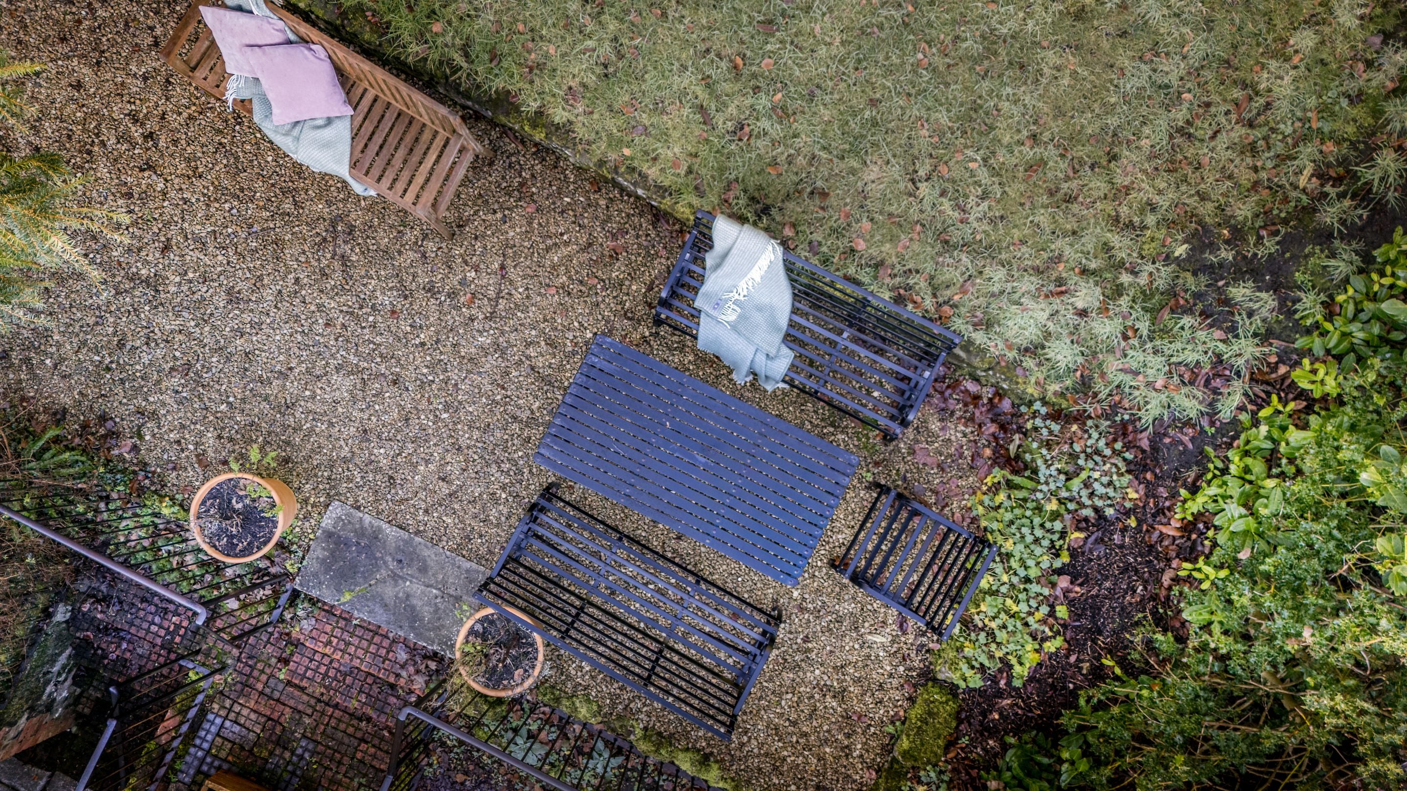 An aerial view of the gravelled area in the back garden of 89 Church Lawn, with a table and benches, Wiltshire