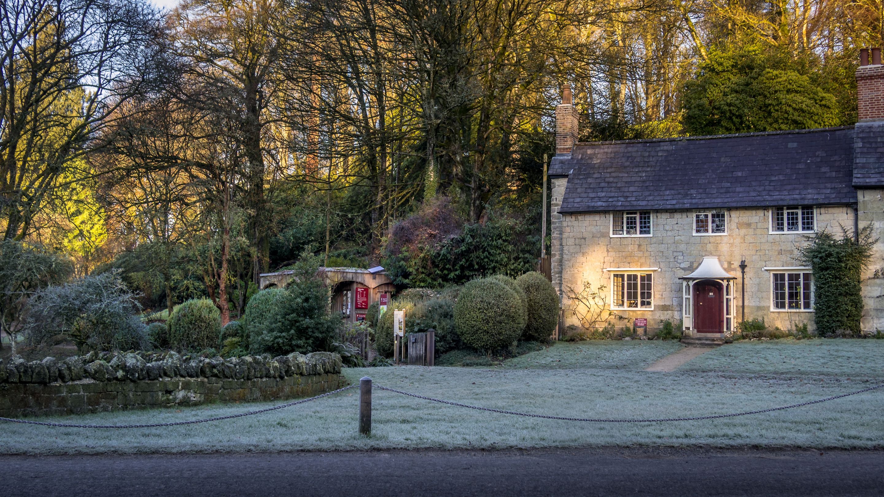 89 Church Lawn and the entrance to Stourhead's garden, with winter frost on the lawn in front of the cottage, Wiltshire