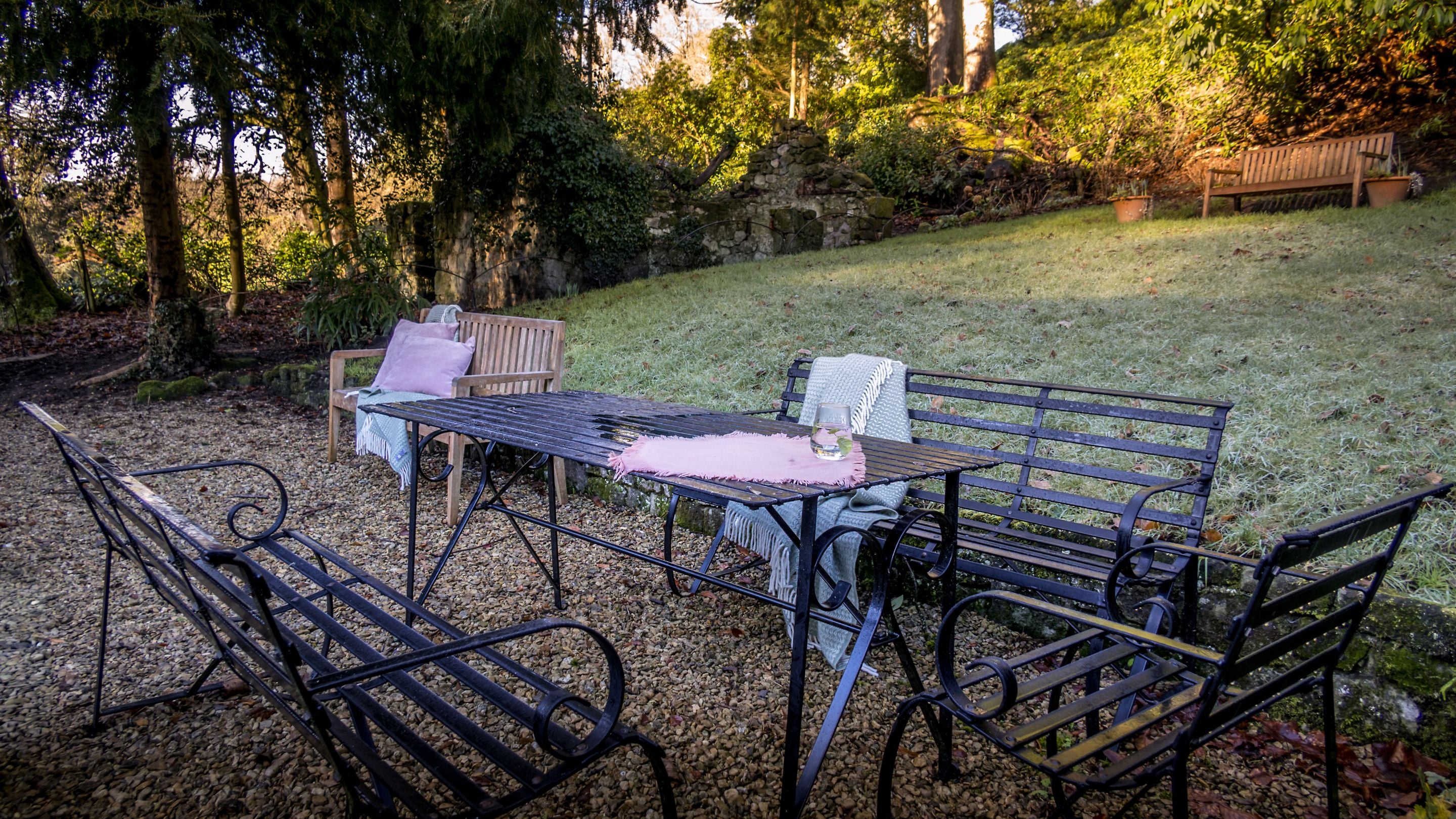 89 Church Lawn's private garden, with sloped lawn and a flat gravelled area with outdoor furniture, Wiltshire