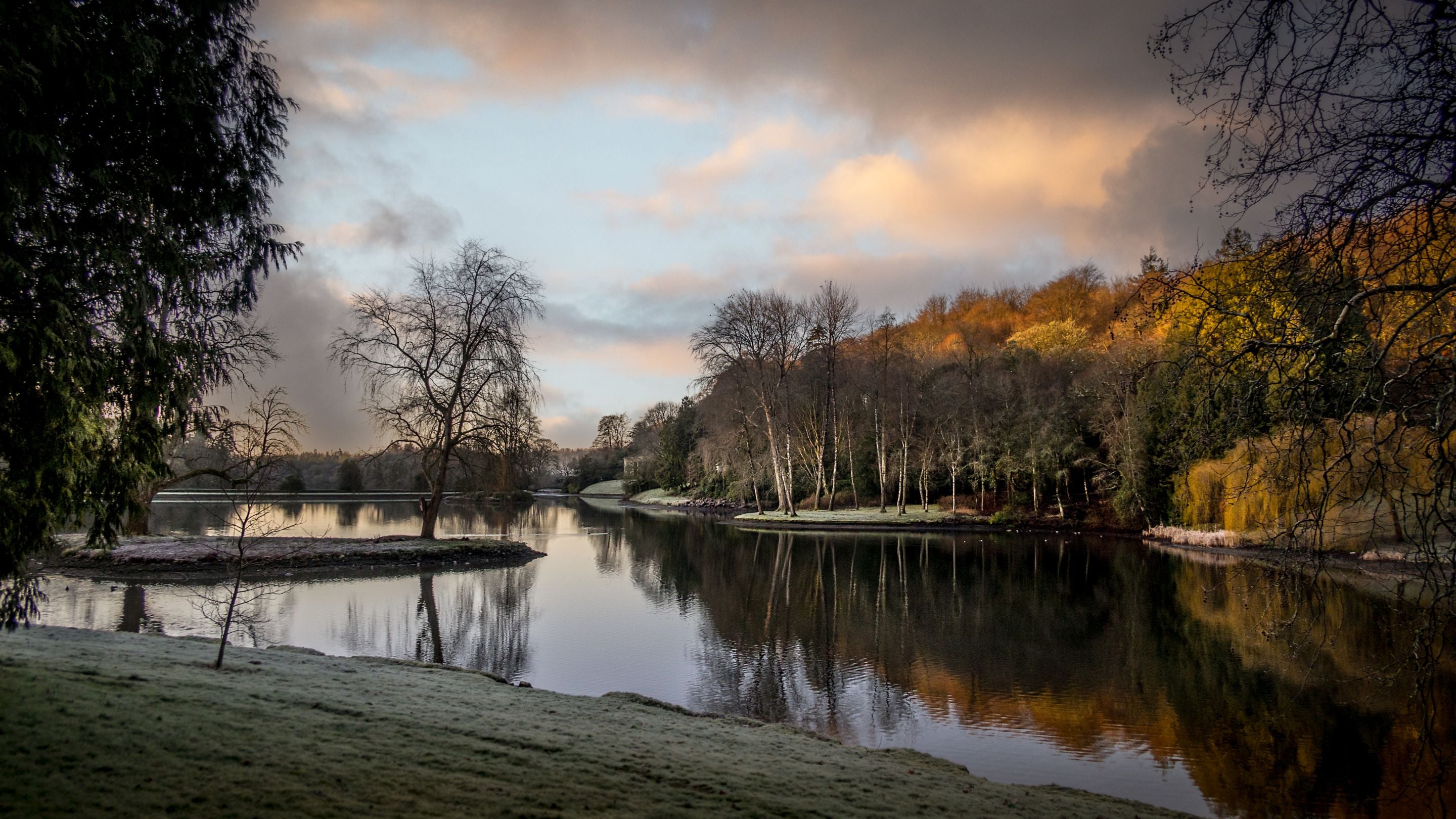 The lake in the landscaped garden at Stourhead, surrounded by trees, Wiltshire