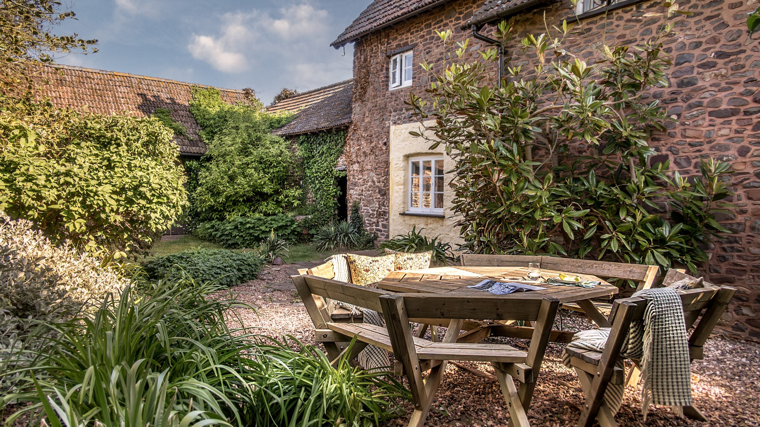 A table and chairs in the garden at Holnicote Lower House, Somerset