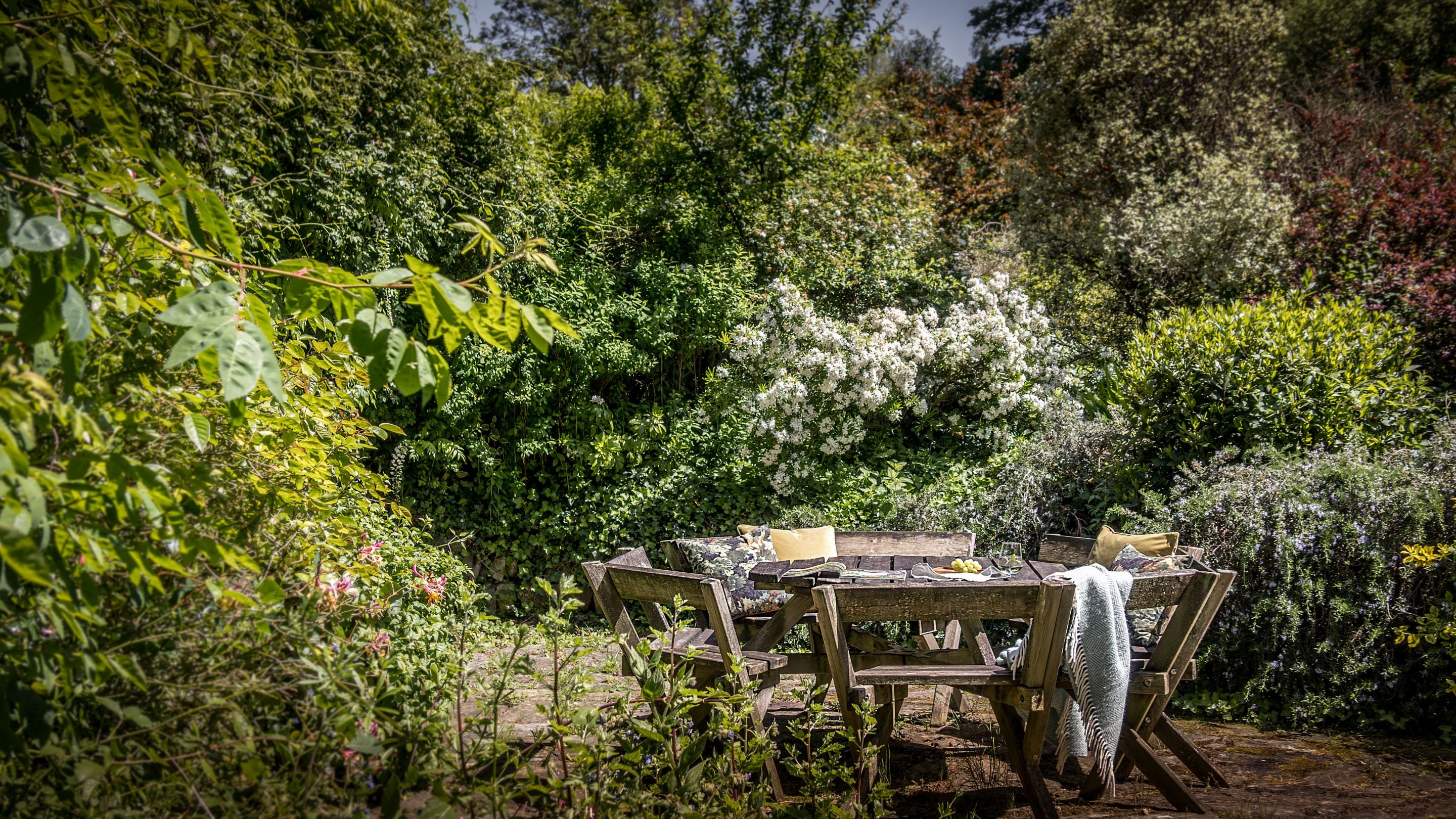 Table and chairs on the patio area at Selworthy Farmhouse, Somerset