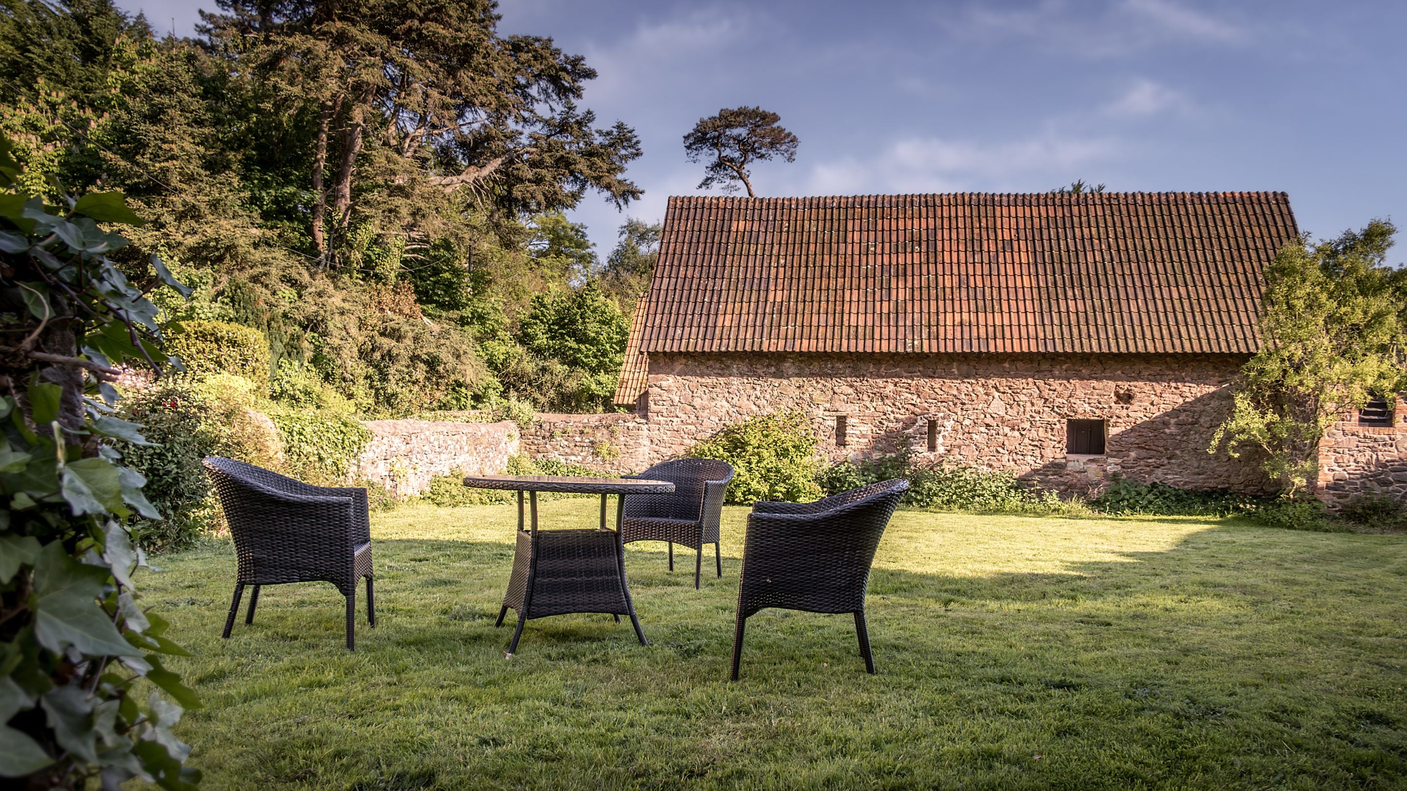 Table and chairs in the garden at Selworthy Farmhouse, Somerset
