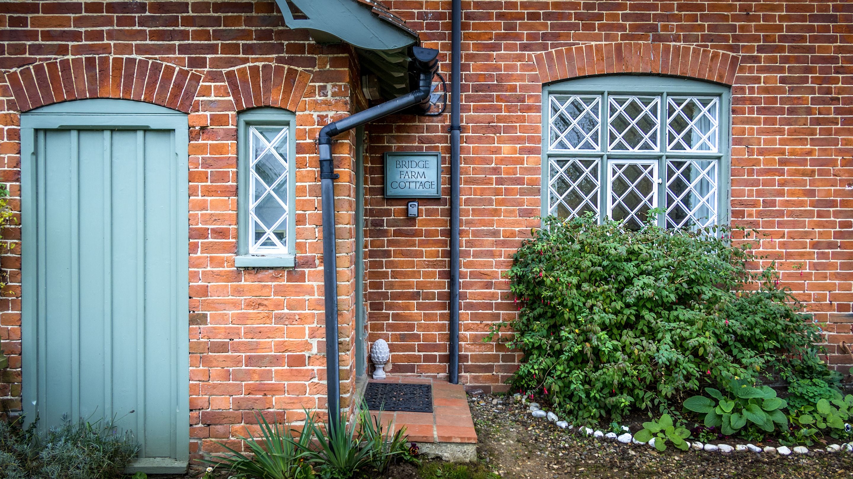 The front of Bridge Farm Cottage, showing the step up to the front door, Suffolk