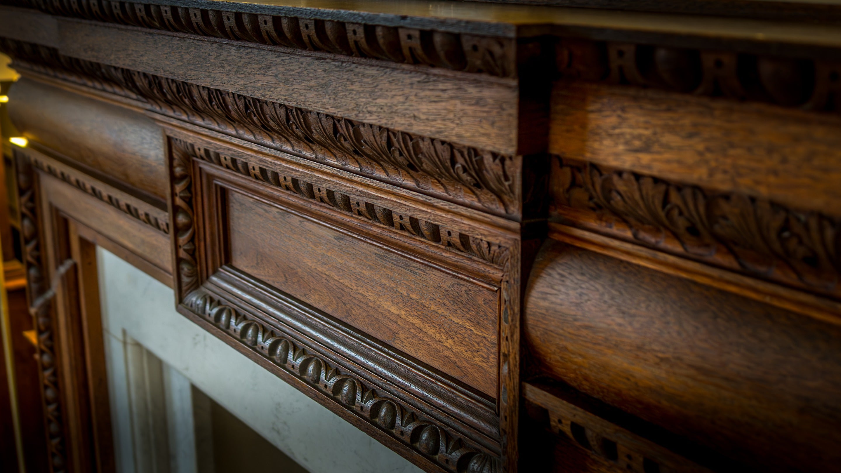 The ornamental fireplace (not in use) at Deben View, with marble hearth and carved wooden mantlepiece, Suffolk