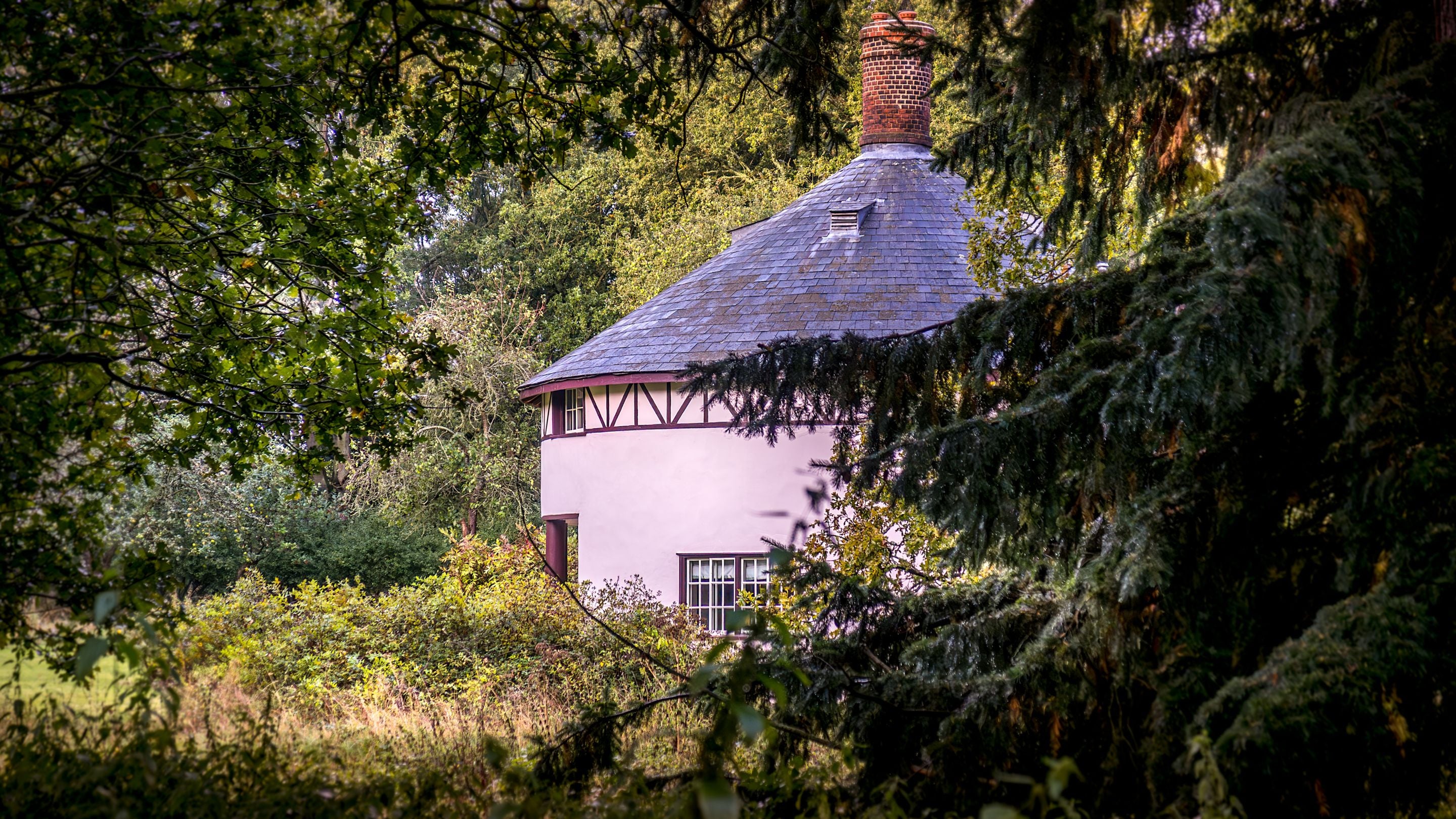 The Round House, peeking through the surrounding woodland, Suffolk
