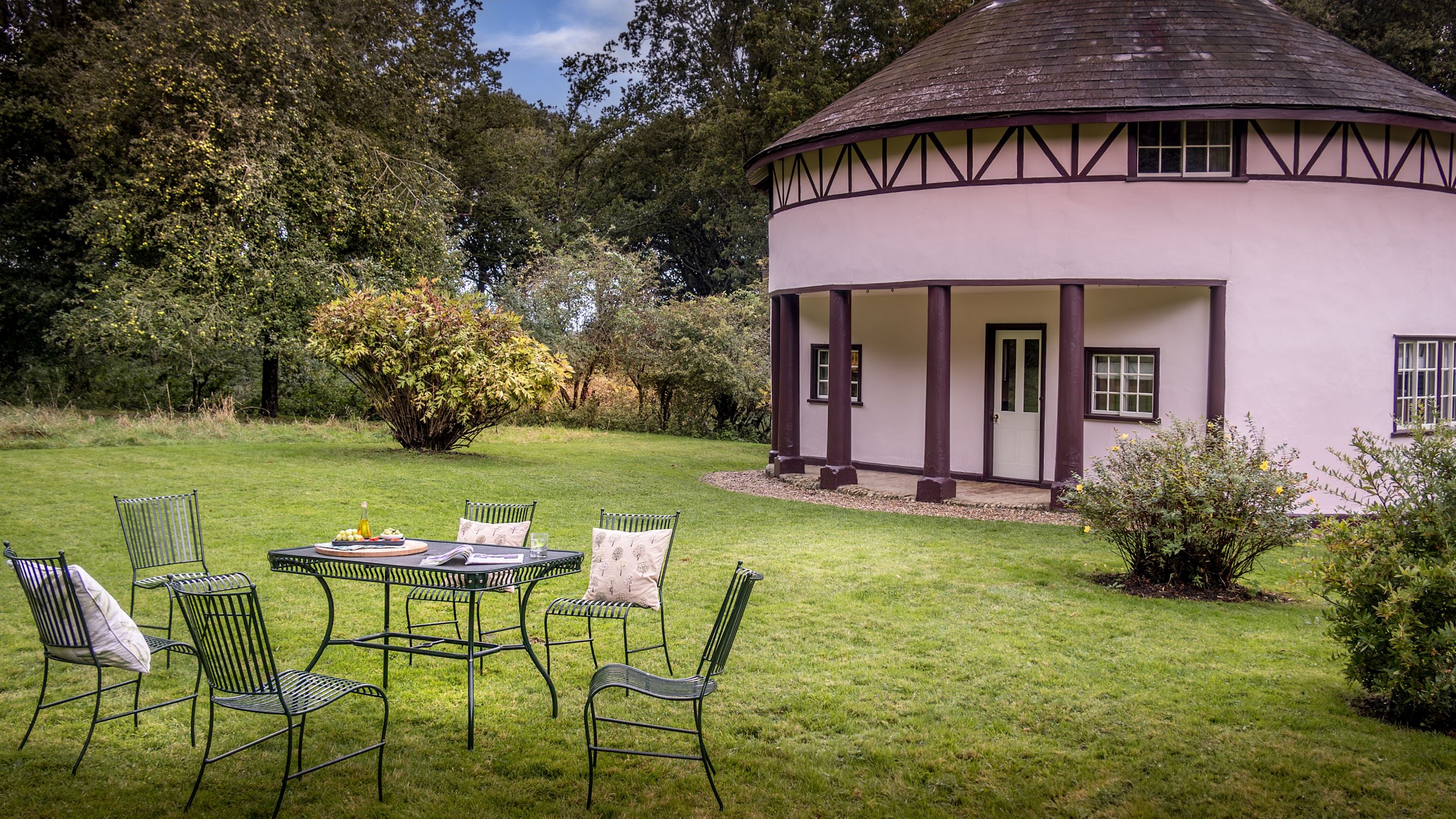 The large, lawned garden with outdoor dining furniture at The Round House, Suffolk