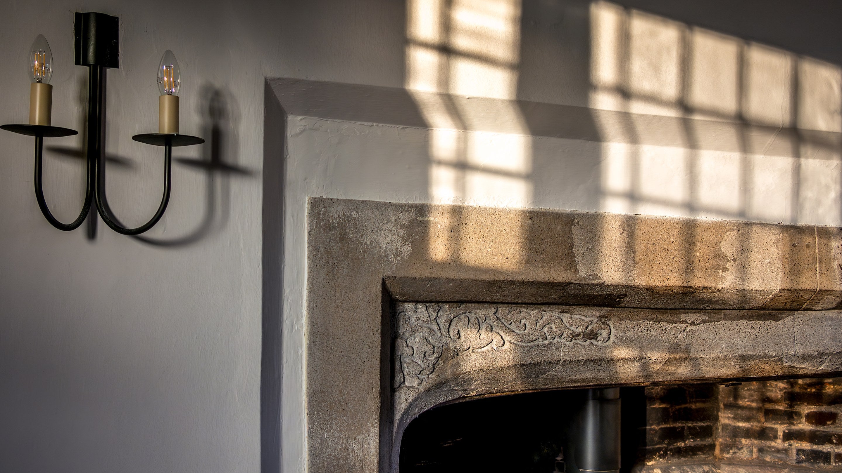 Carved details in the stone of the fireplace in the dining room at Thorington Hall, Suffolk