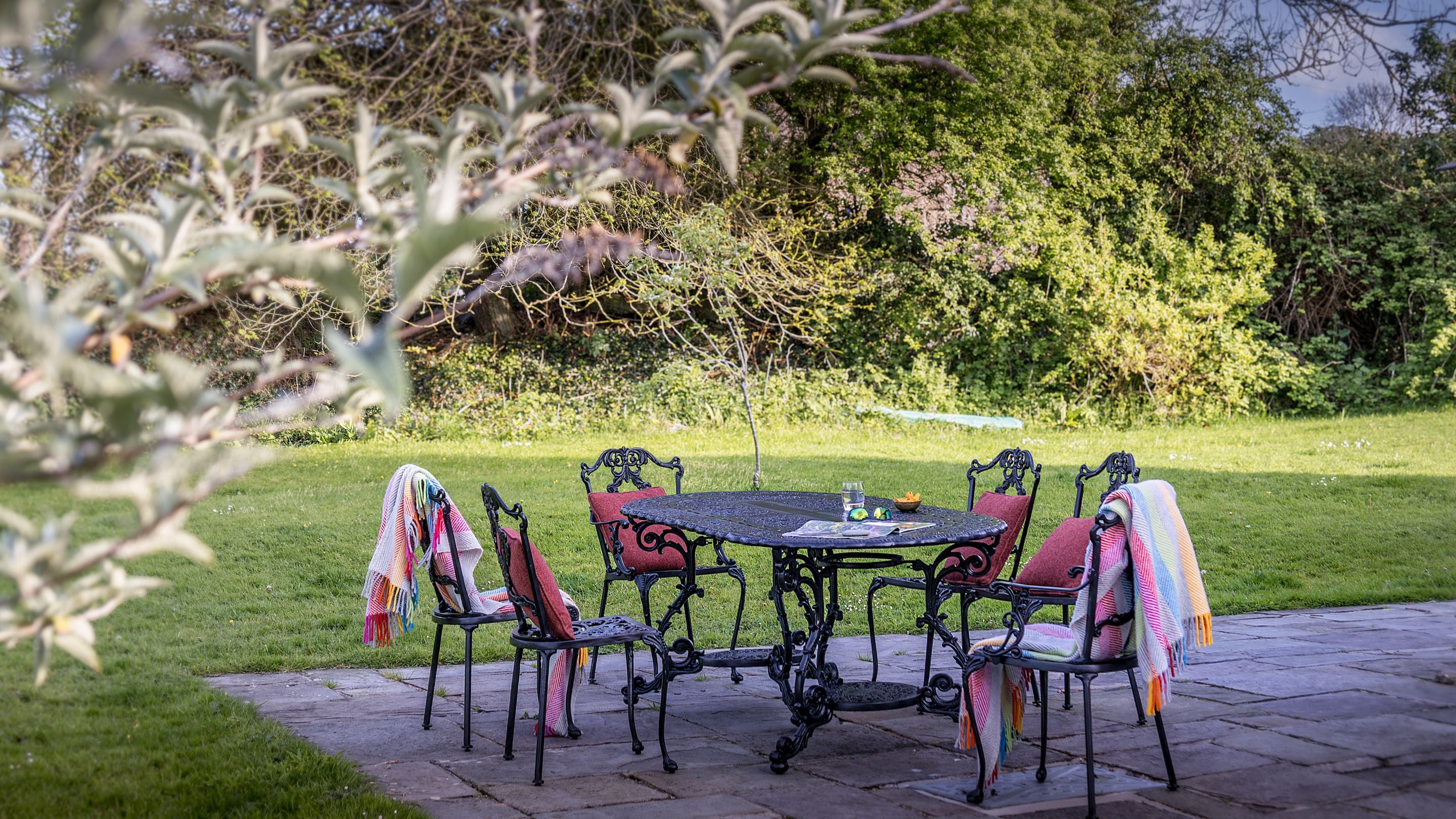 The garden patio with outdoor dining furniture at Caerllan, Ceredigion