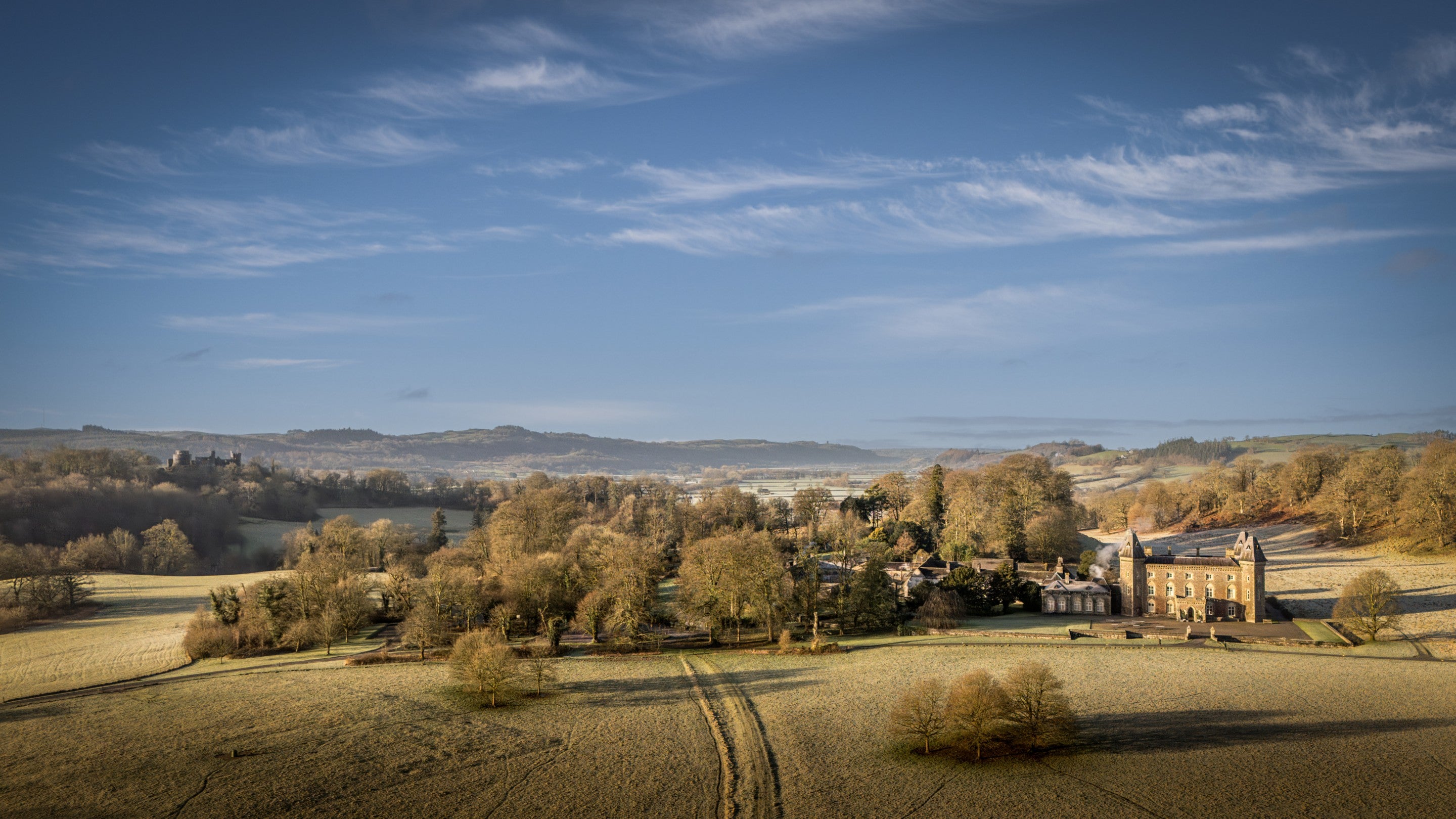 An aerial view of Dinefwr, with Newton House on the right and Dinefwr Castle in the background on the left, Carmarthenshire