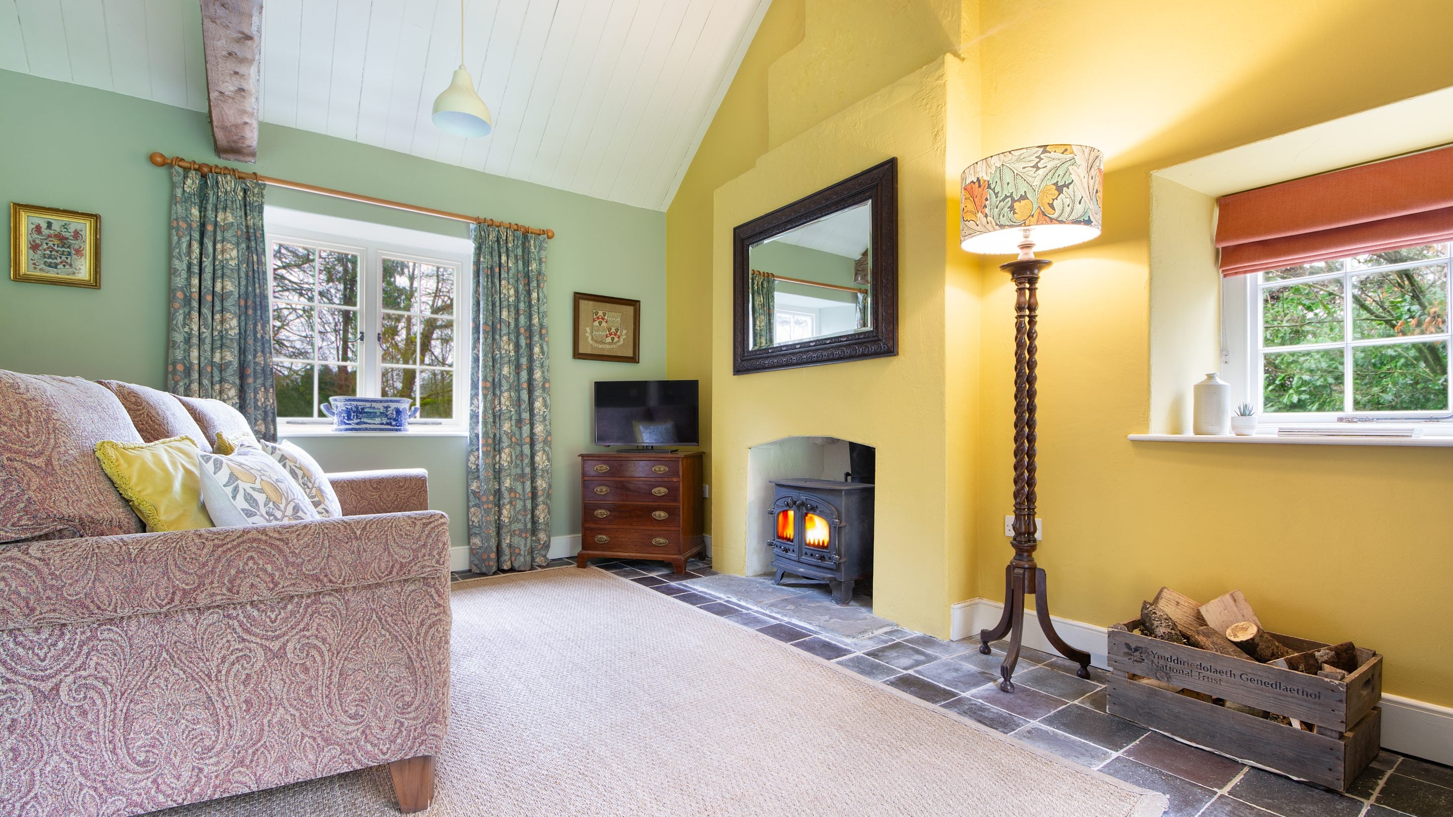 The sitting area with sofa, television and woodburner at Cariad Cottage, Carmarthenshire