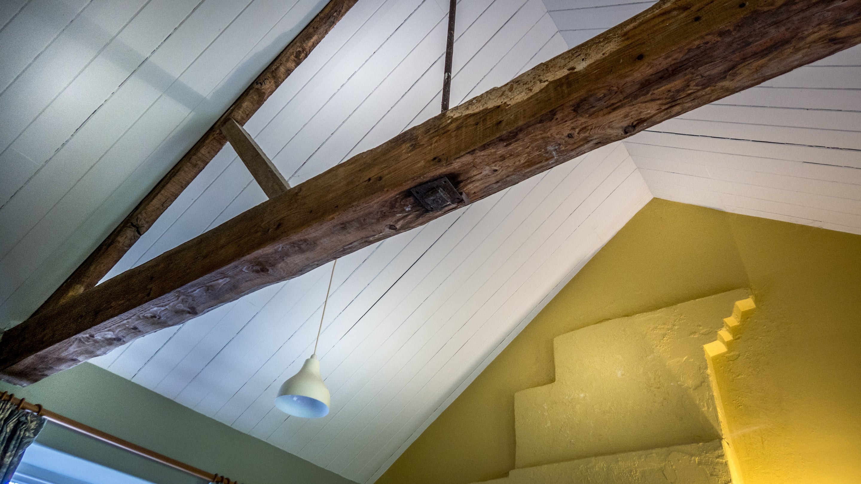 The vaulted ceiling and exposed beams in the living space at Cariad Cottage, Carmarthenshire
