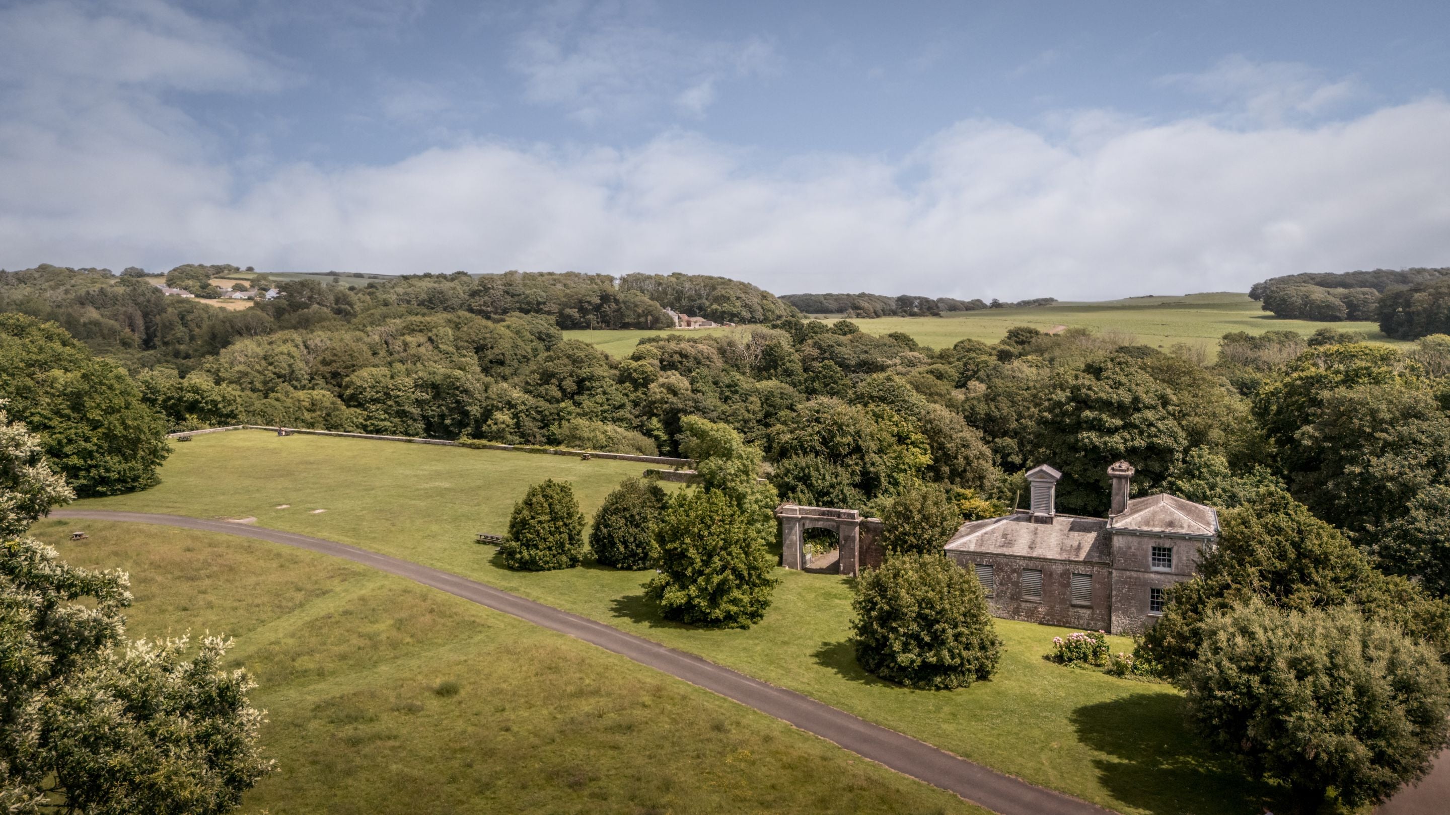 An aerial view of Cawdor and the attached buildings, with Stackpole's parkland beyond, Pembrokeshire