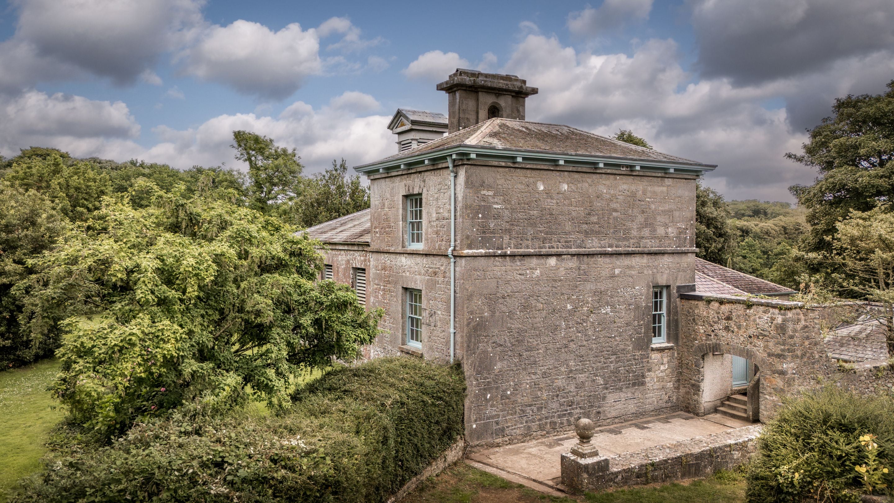 An aerial view of Cawdor and the path and steps to the front door through a stone archway, Pembrokeshire