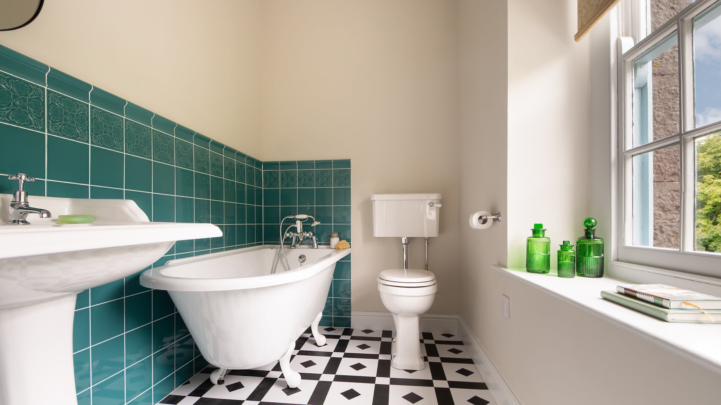 The bathroom with roll-top bath with shower attachment, on the first floor of Cawdor, Pembrokeshire