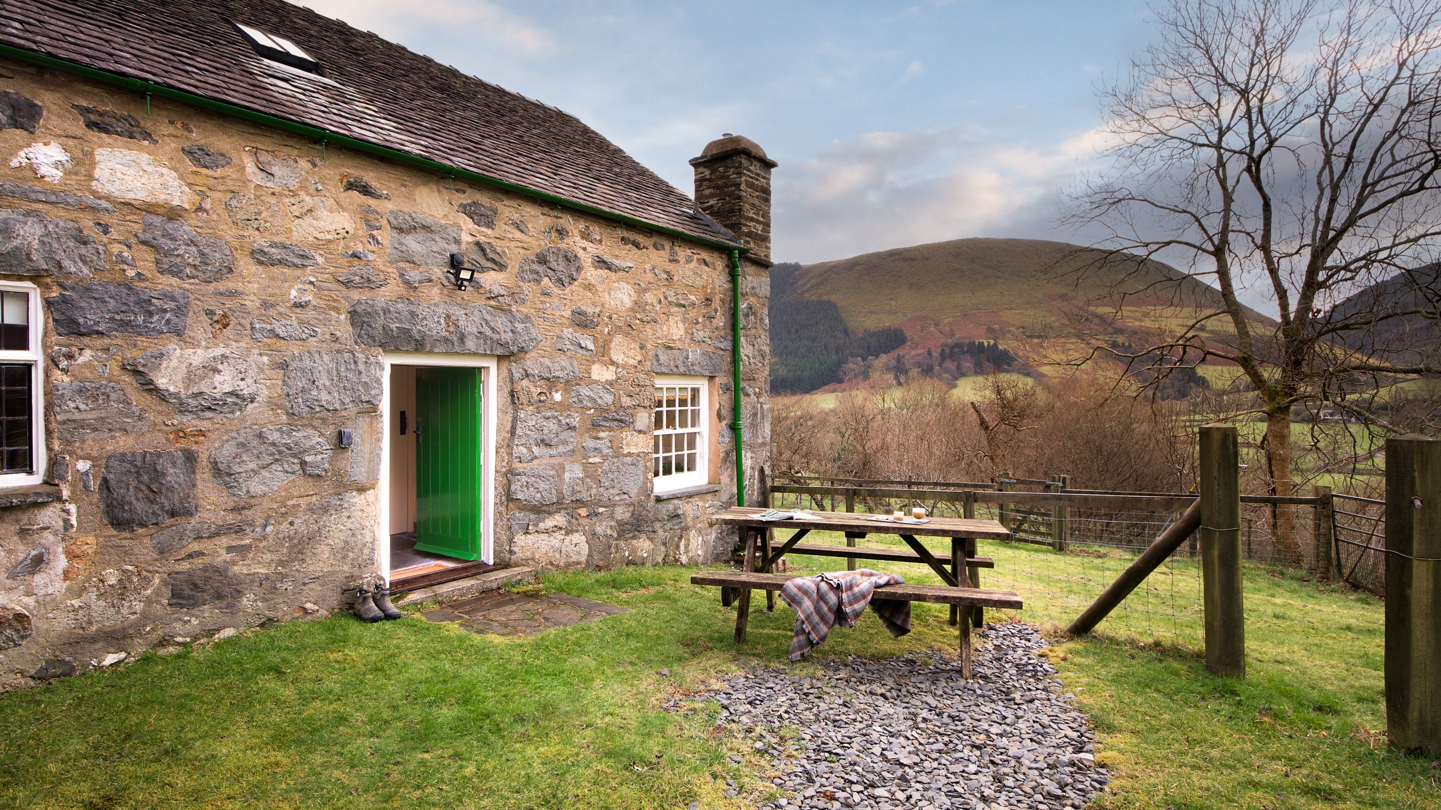 The back garden with picnic bench and valley views at Fron Dirion, Powys