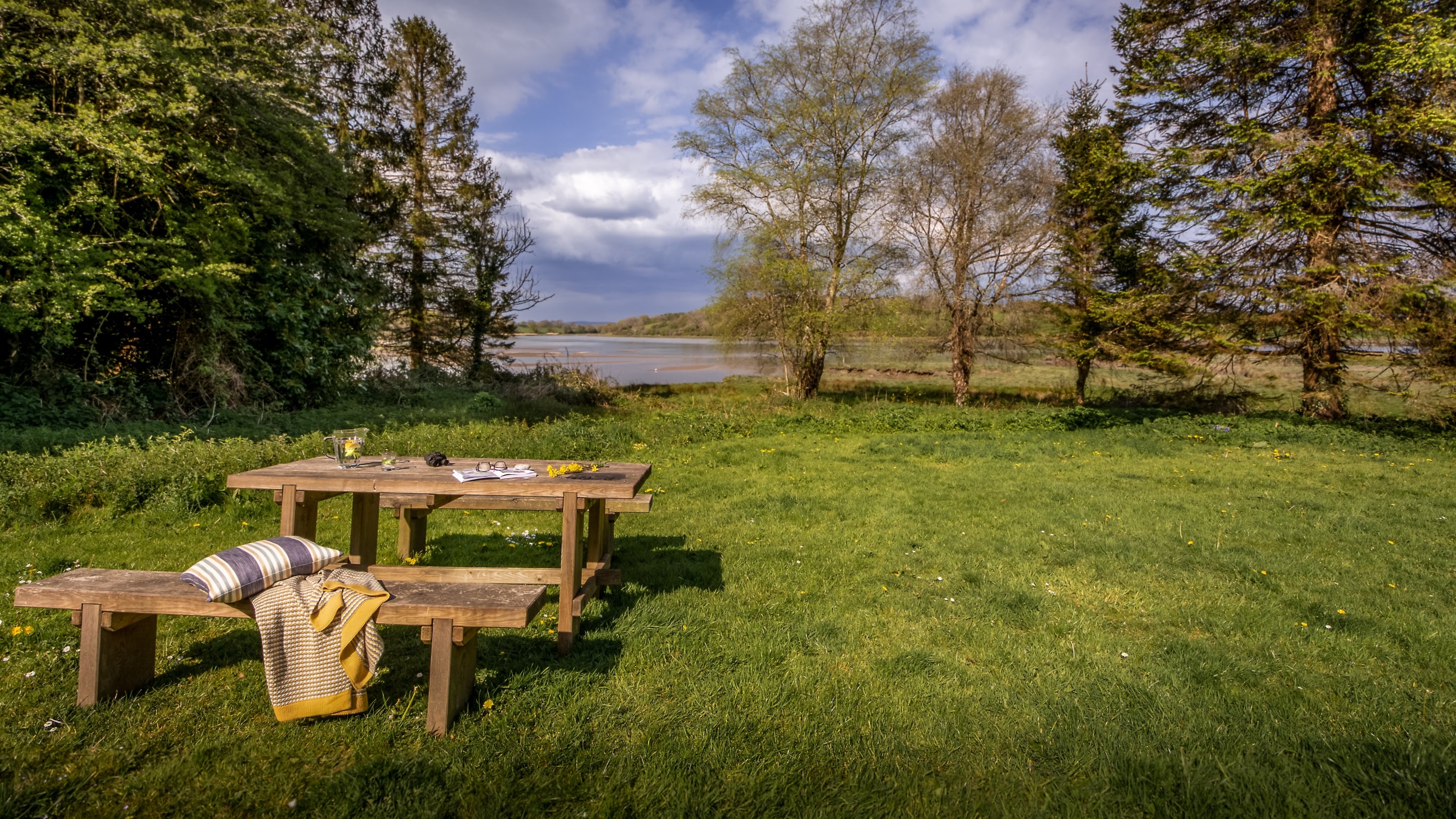 Little Milford Farmhouse's garden, on the bank of the River Cleddau, with lawn and outdoor dining furniture, Pembrokeshire
