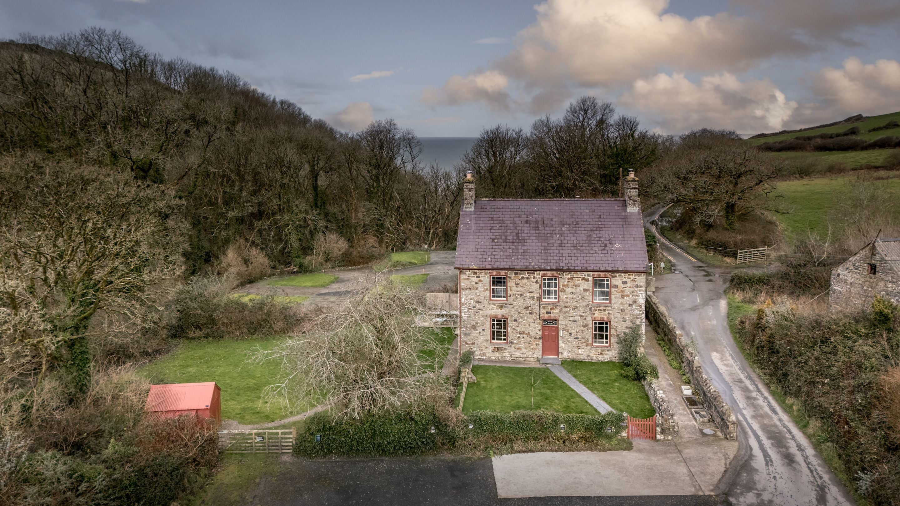 Llanborth Farmhouse with the sea in the distance, Ceredigion