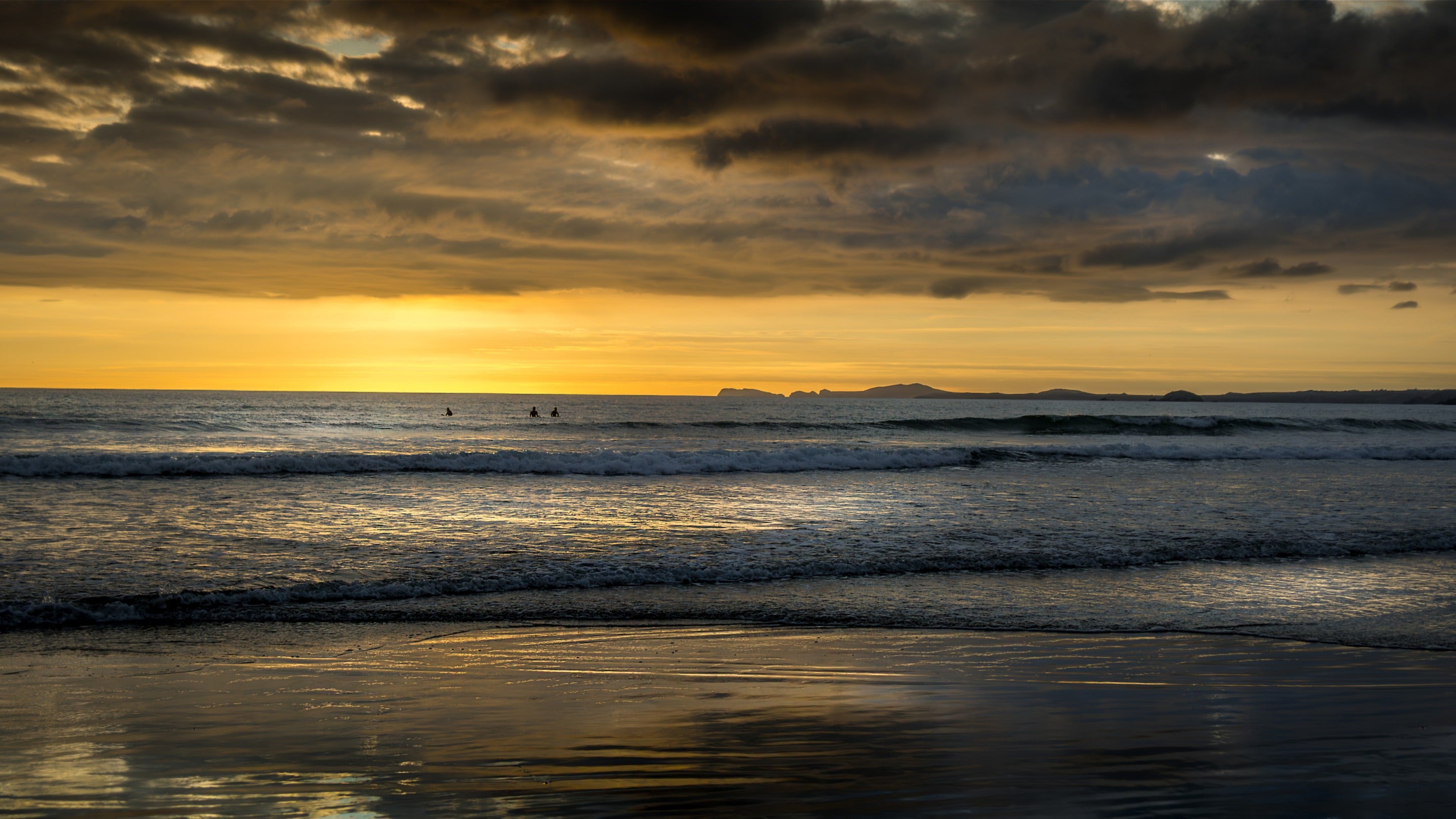 Surfers at Newgale Beach at sunset, Pembrokeshire